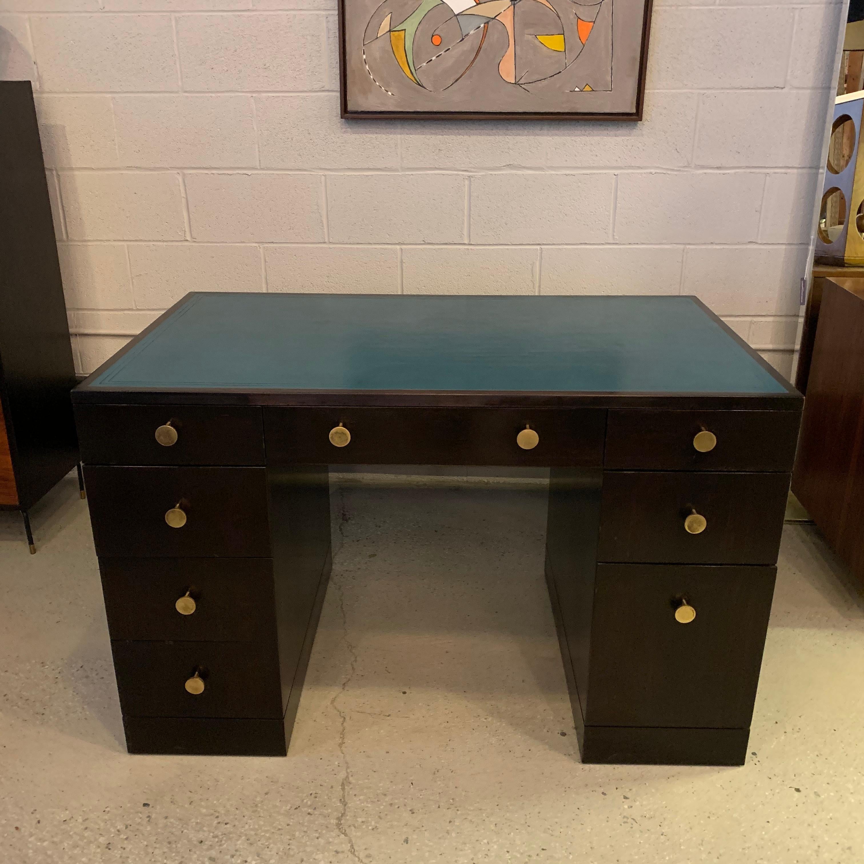 Small yet stately, black lacquered rosewood desk by Edward Wormley for Dunbar circa 1950s features a scored turquoise green/blue leather top with fantastic brass pulls. The desk has 8 drawers, some with dividers, with the lower right one able to