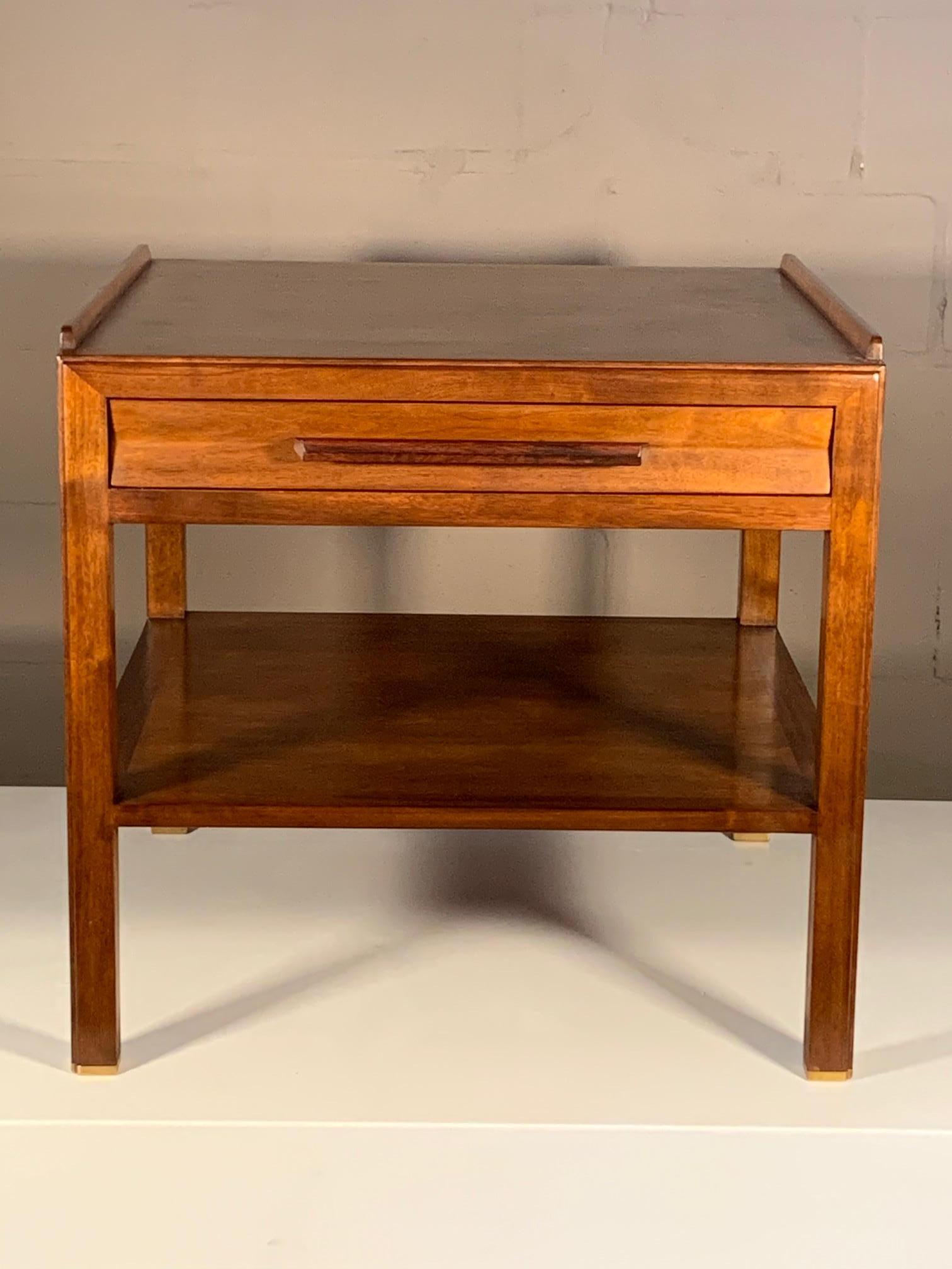 A classic Edward Wormley, Dunbar lamp table in walnut with long rosewood handle. Generous scale and very heavy, with solid brass sabots, sculpted drawer front, raised edge on top make this a real stand out. The genius of Edward Wormley of mixing and