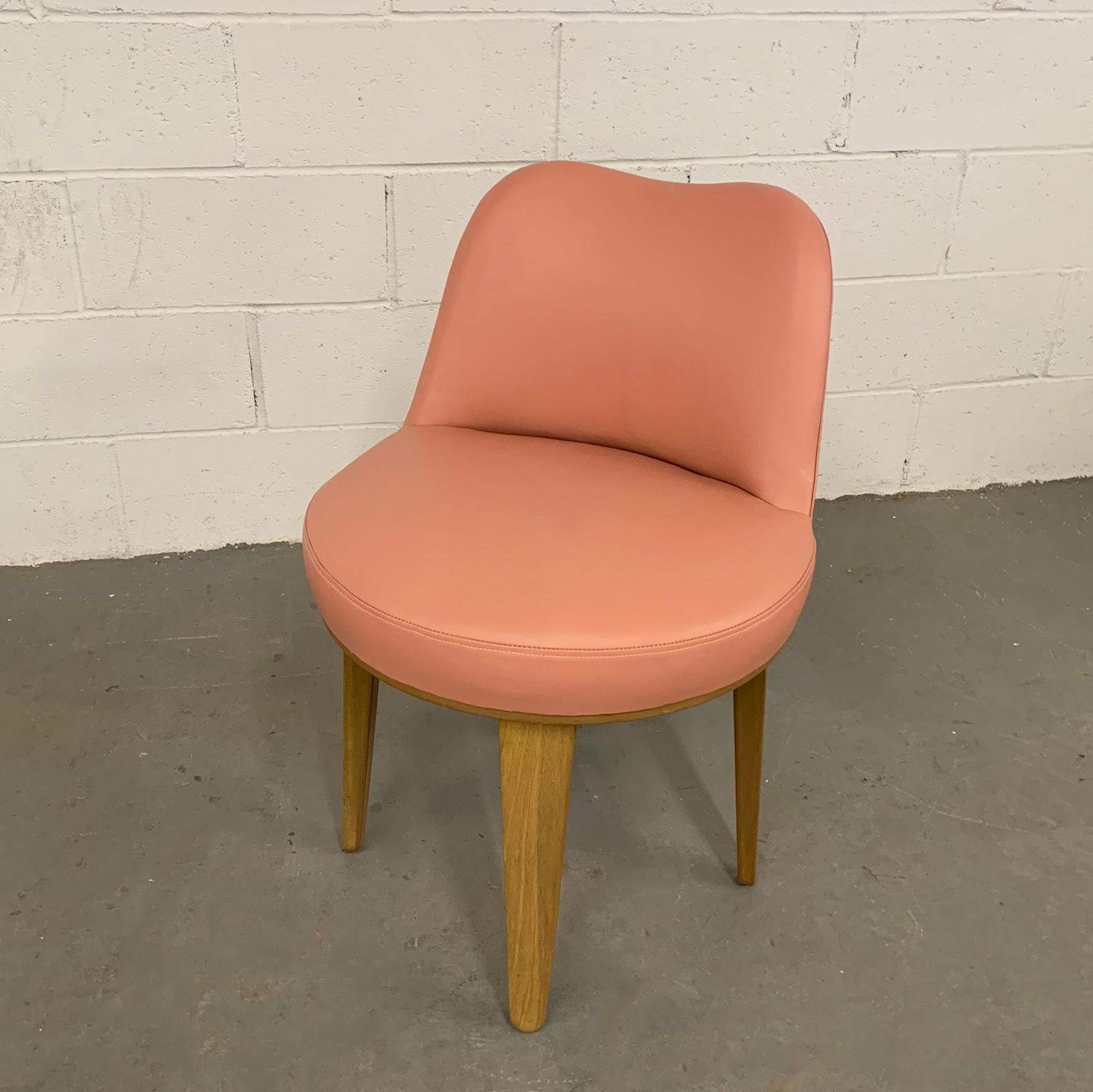 Petite, swivel, pickled mahogany, vanity chair by Edward Wormley for Dunbar is newly upholstered in dusty pink leather. The chair is shown with an Edward Wormley vanity desk that is listed separately.