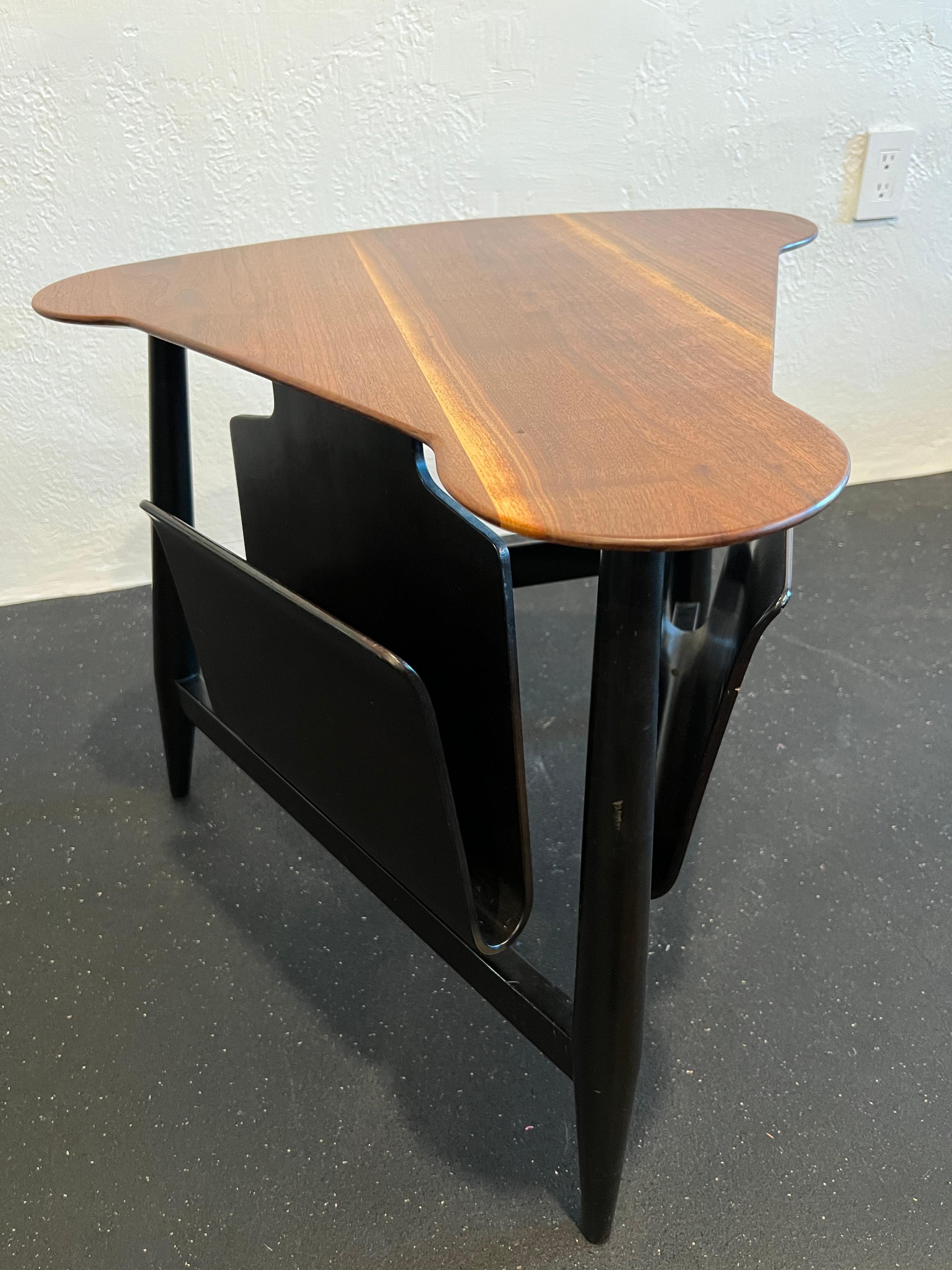 Edward Wormley for Dunbar magazine table. Model 5313. Beautiful striations throughout the mahogany top contrasted by the ebonized base. Note the small divot found on the table top and the wear to the base finish (please refer to photos). Additional