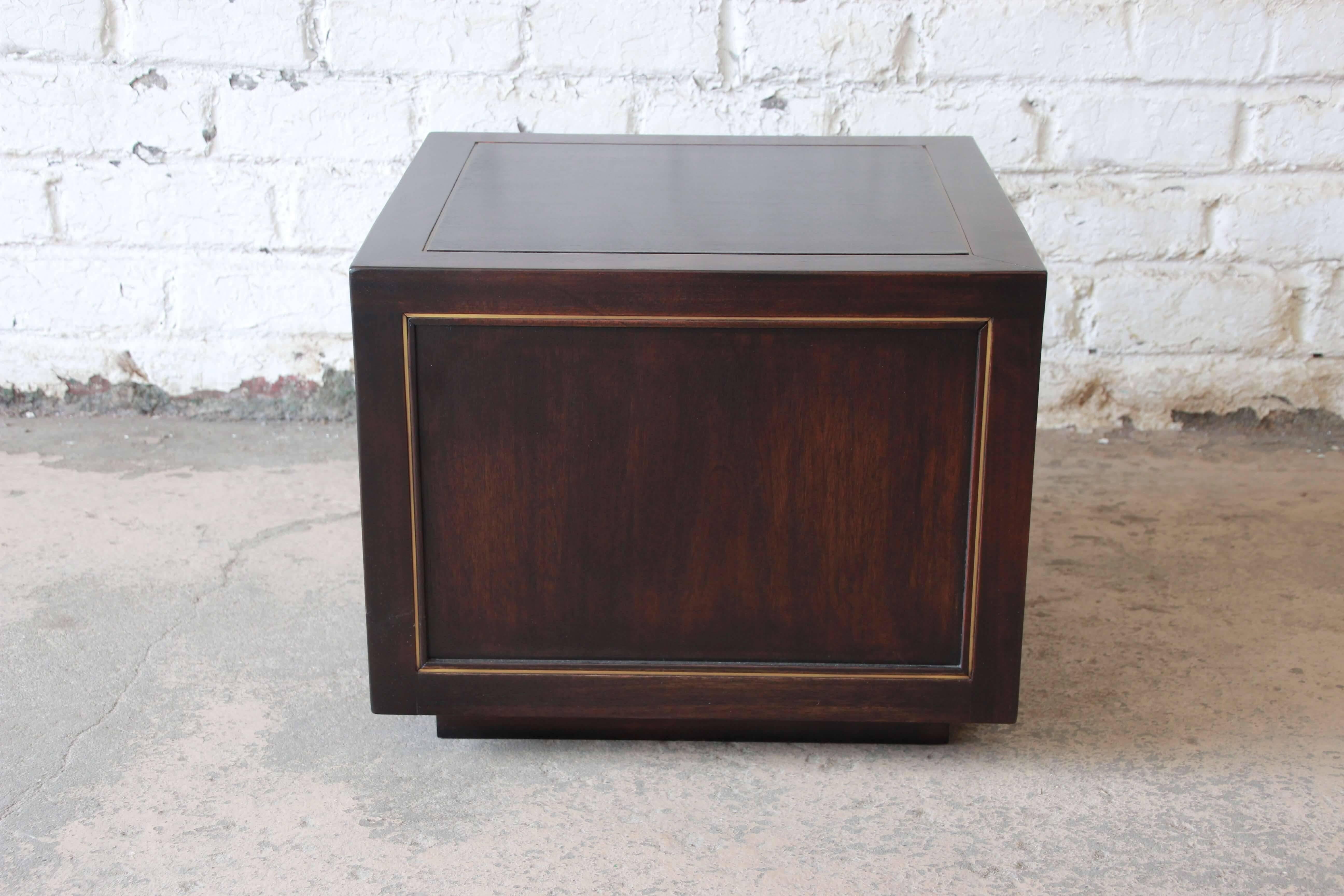 Offering a beautifully restored cube side table by Edward Wormley for Dunbar. The cube features inlaid brass with a sleek onyx finish.