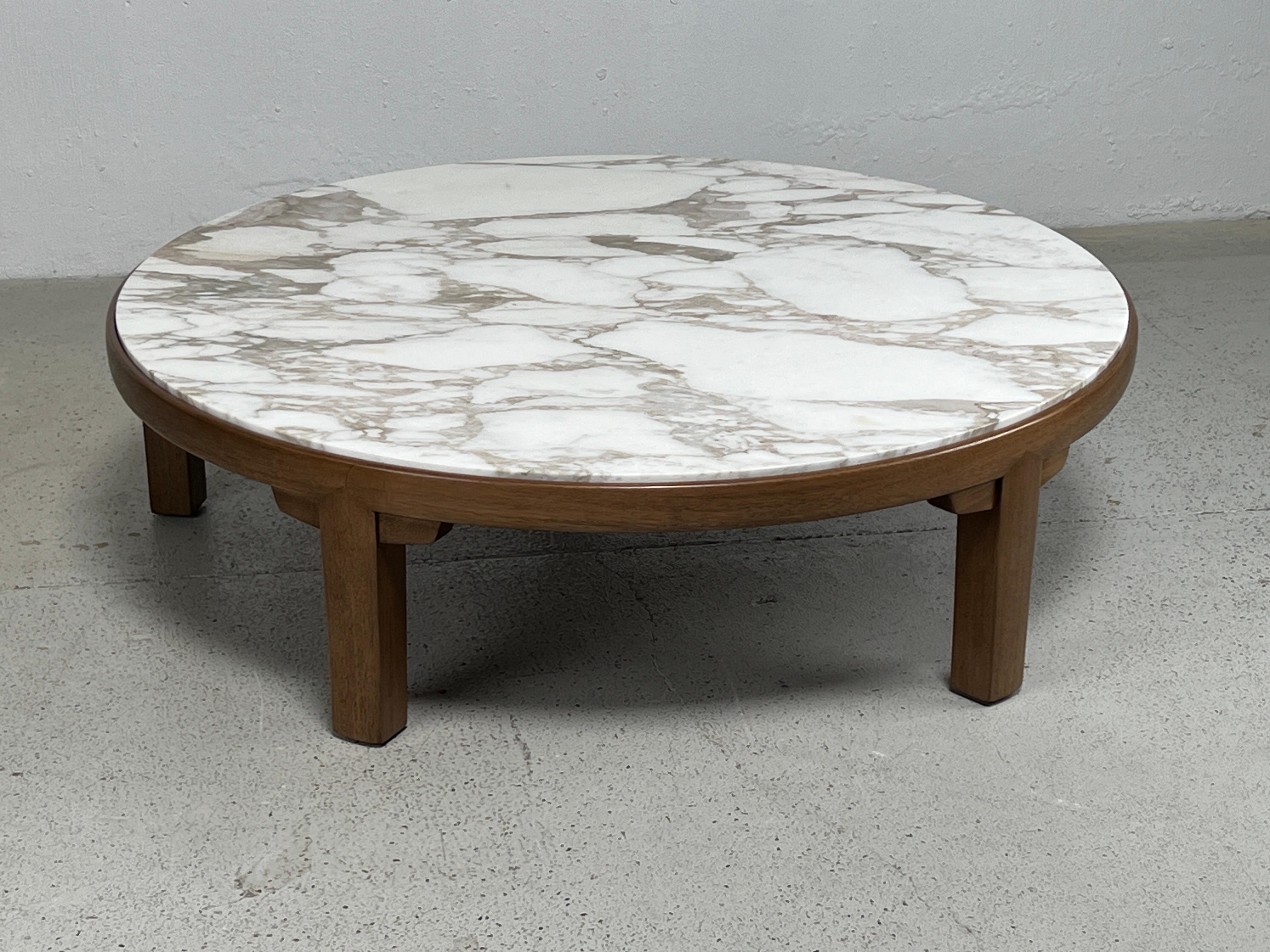 A mahogany coffee table with figurative marble top. Designed by Edward Wormley for Dunbar.