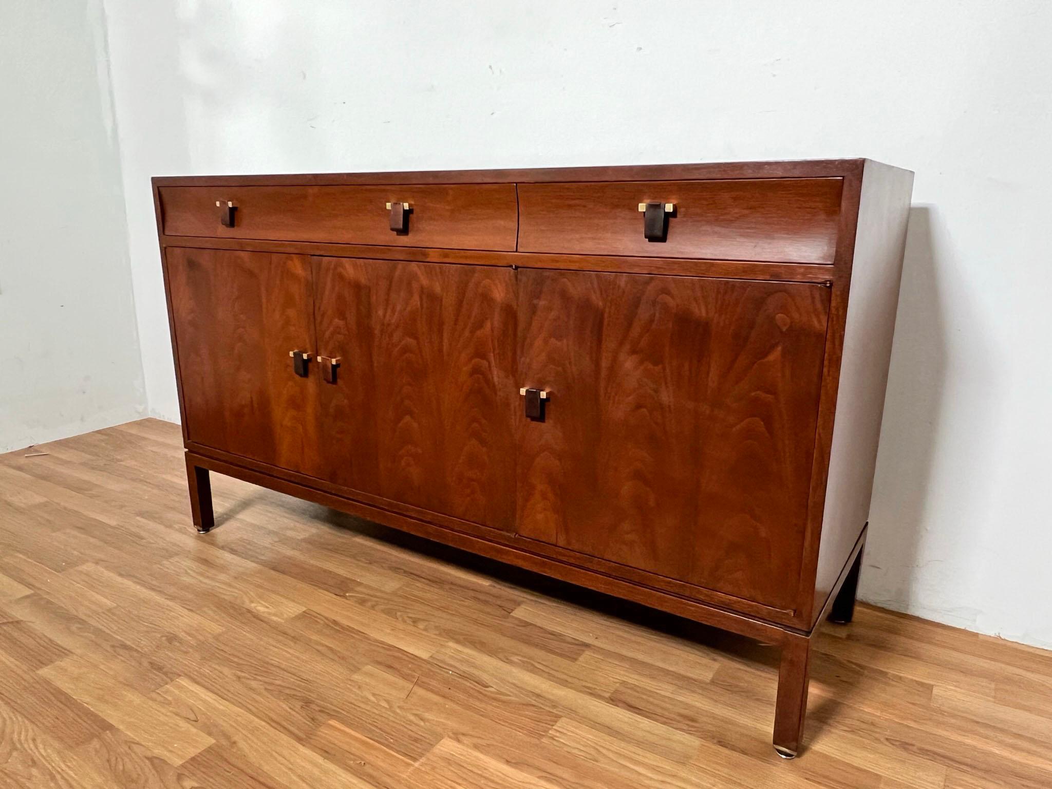 A three door mahogany credenza with rosewood and brass drawer pulls, and three drawers above, designed by Edward Wormley for Dunbar, circa 1950s.