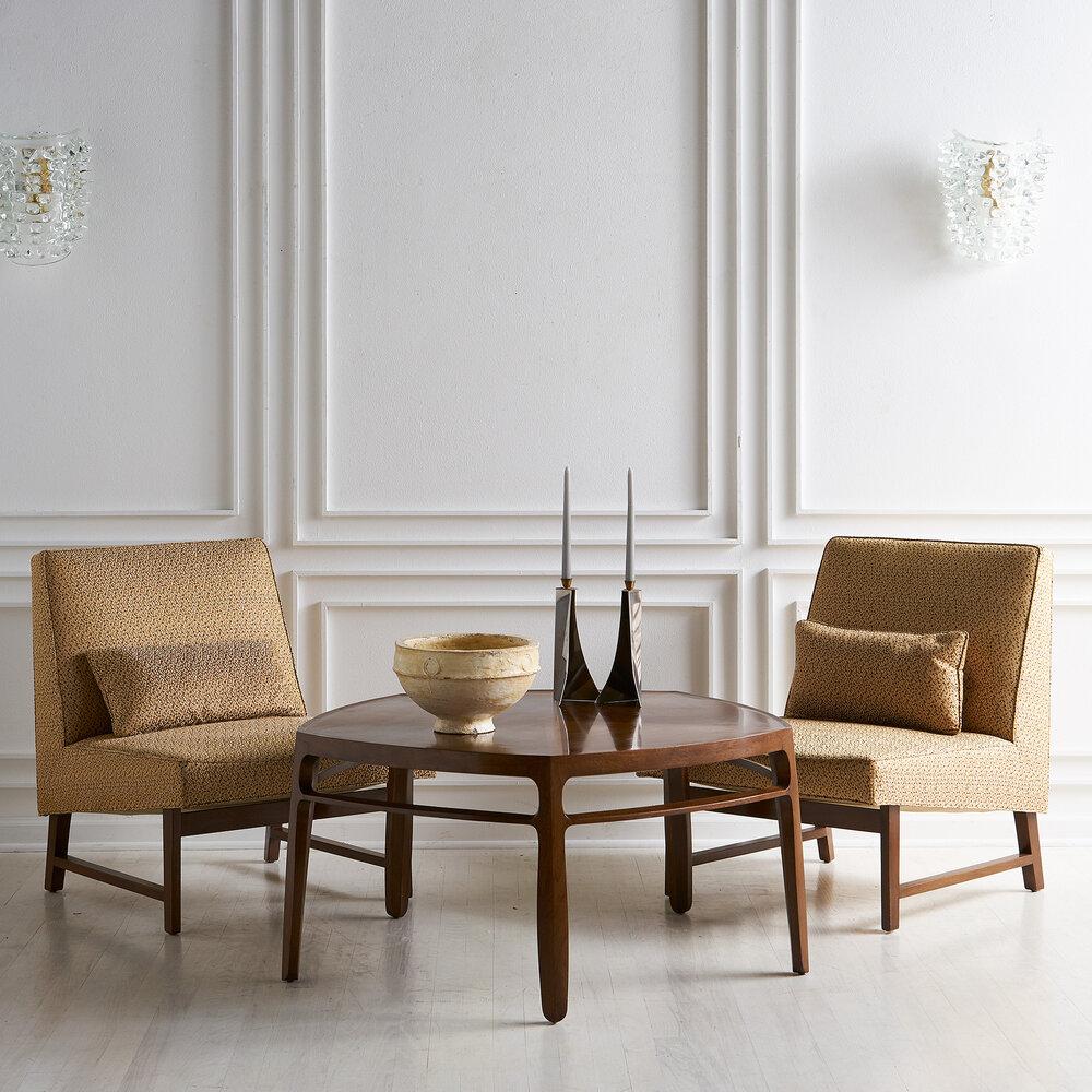 A pair of 1950s Edward Wormley for Dunbar slipper chairs. Featuring a sculptural mahogany wood frame and original upholstery.