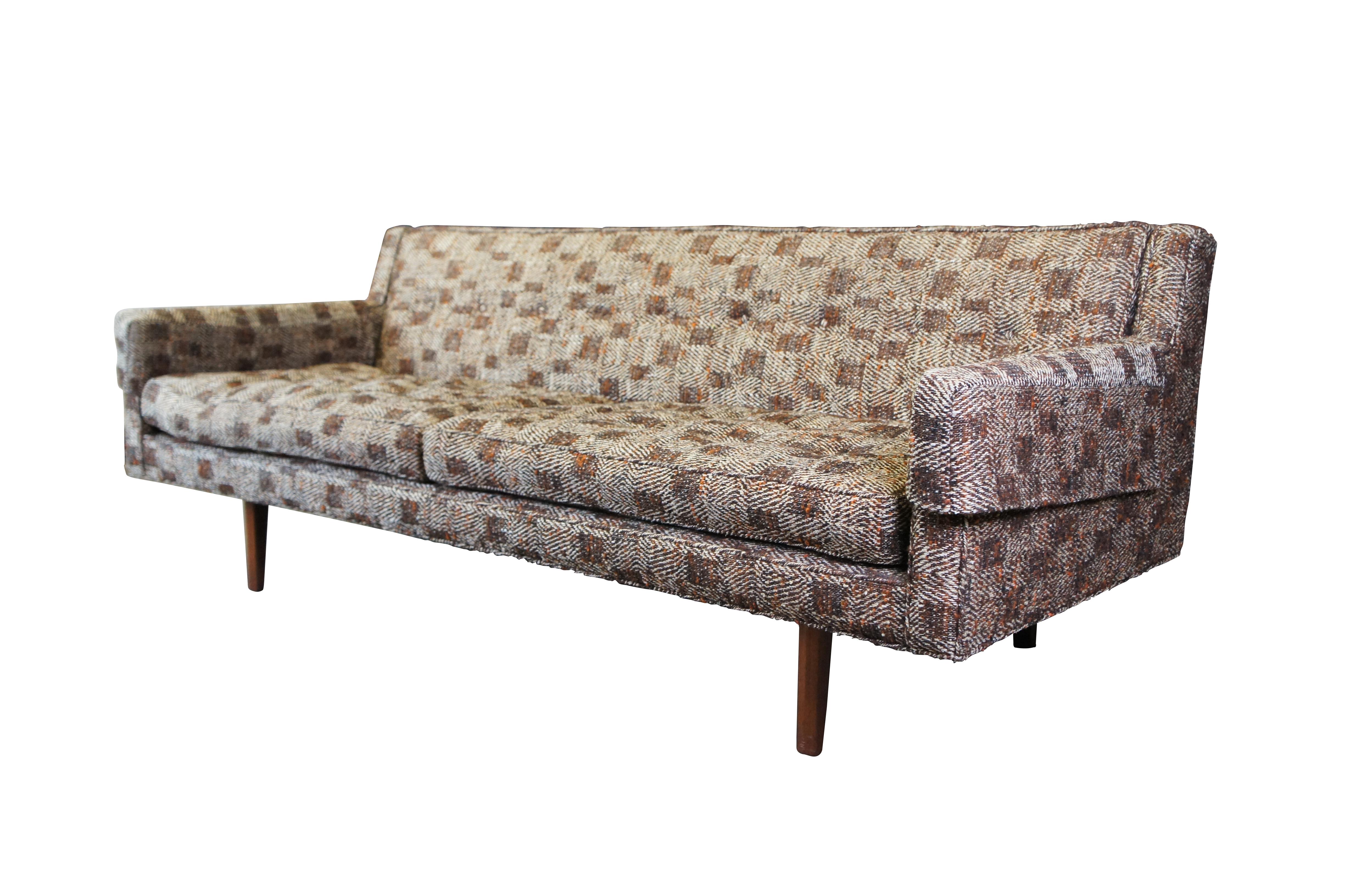 Canapé Edward Wormley for Dunbar Atomic Era Bracket Back Sofa, circa 1950s.  Il est doté d'accoudoirs profilés, d'un capitonnage original en tweed plaqué et de deux grands coussins d'assise.  Le canapé est soutenu par des pieds modernes et