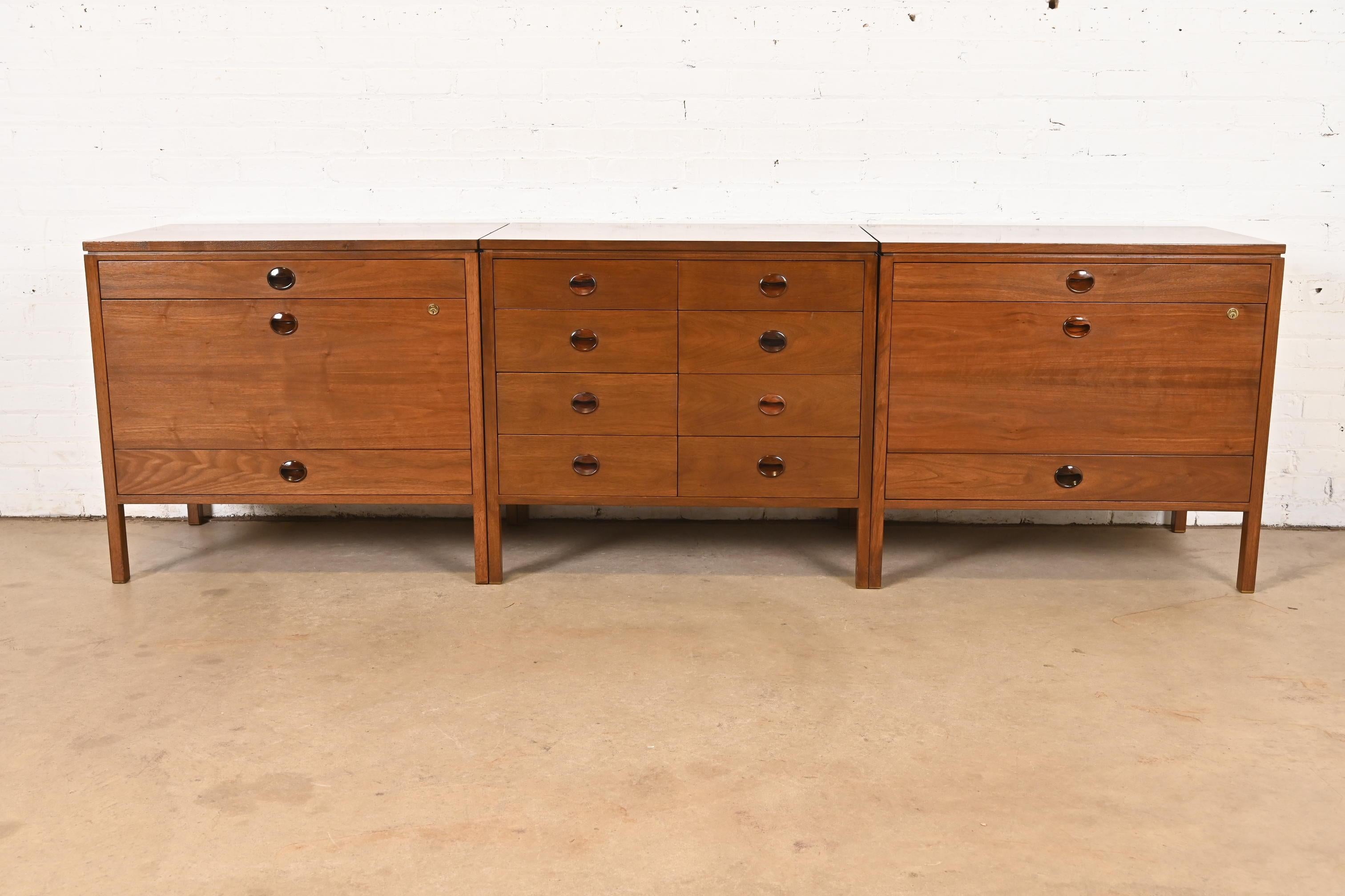 Un'eccezionale credenza direzionale a tre pezzi in stile Mid-Century Modern, che comprende un armadio a otto cassetti e due armadi a tre cassetti con ampi cassetti per cartelle.

Di Edward Wormley per Dunbar Furniture

USA, circa anni