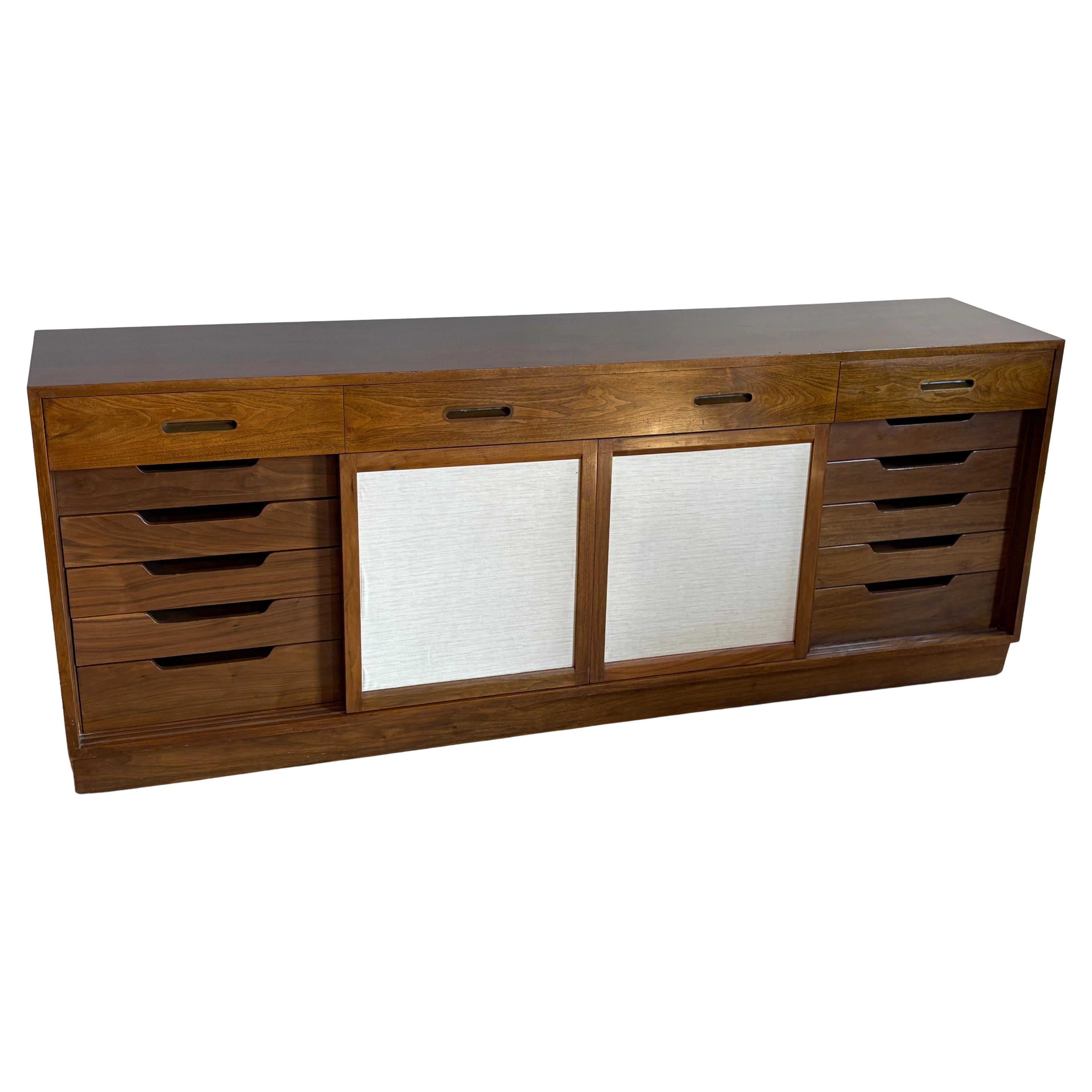 Credenza o credenza degli anni '50 di Dunbar. 

Disegnato da Edward Wormley. Questo è il modello 5668A.

Dispone di 4 ante scorrevoli, 13 cassetti a coda di rondine e scaffali regolabili in altezza al centro. Splendido noce su tutto il perimetro.