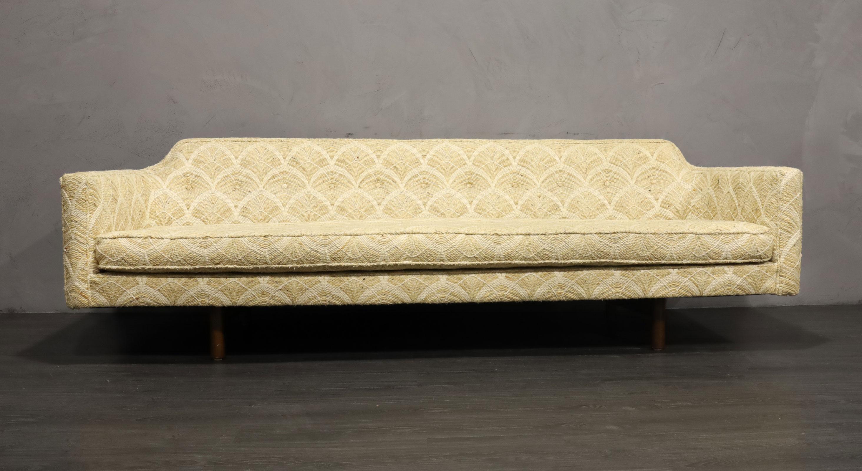 This sofa has beautiful lines and a gently curved back. A true classic. The fabric is original and in very good condition. It is a rich and high-quality texture that looks like embroidery so if it works with your decor I would leave as is. It can