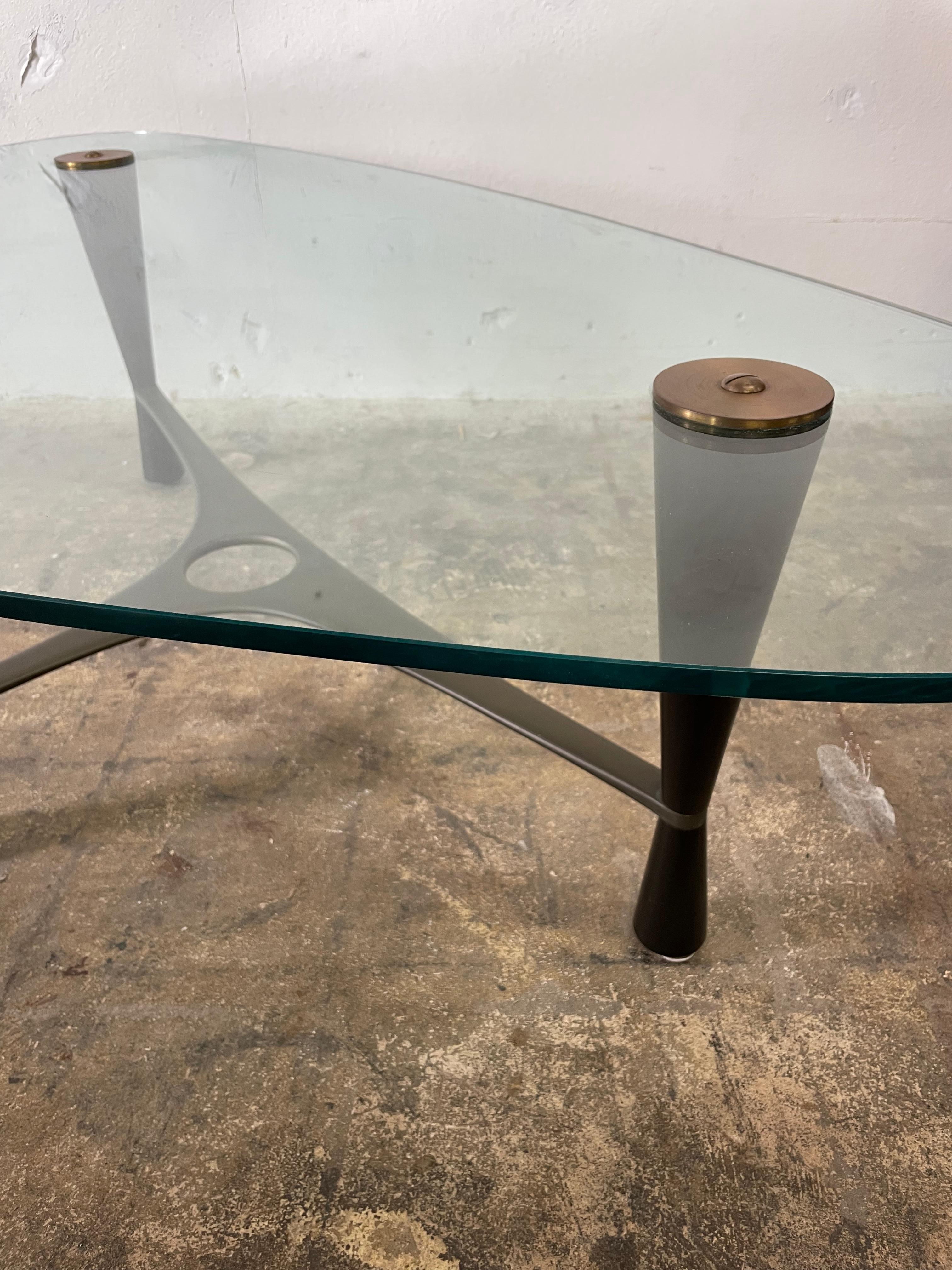 Iconic and Rare Edward Wormley for Dunbar coffee table. Model 5309. Brass stretcher. Original asymmetrical glass top. Ebonized wood. Original condition.