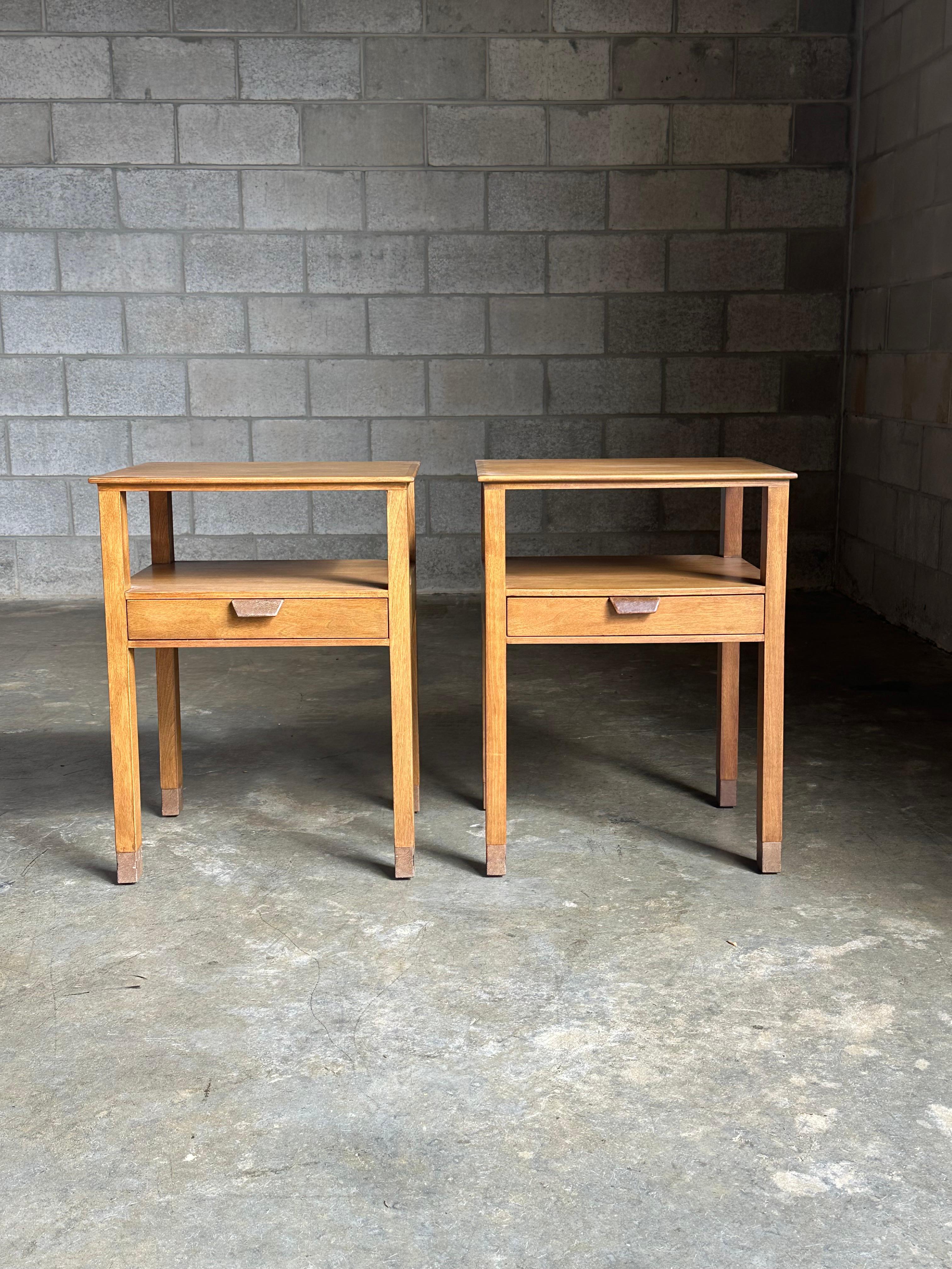 A rare pare of nightstands designed by Edward Wormley for Dunbar circa 1950s. Features a bleached walnut body complete with patinated leather accents for the drawer pull and feet. These are quite uncommon nightstands that do not regularly