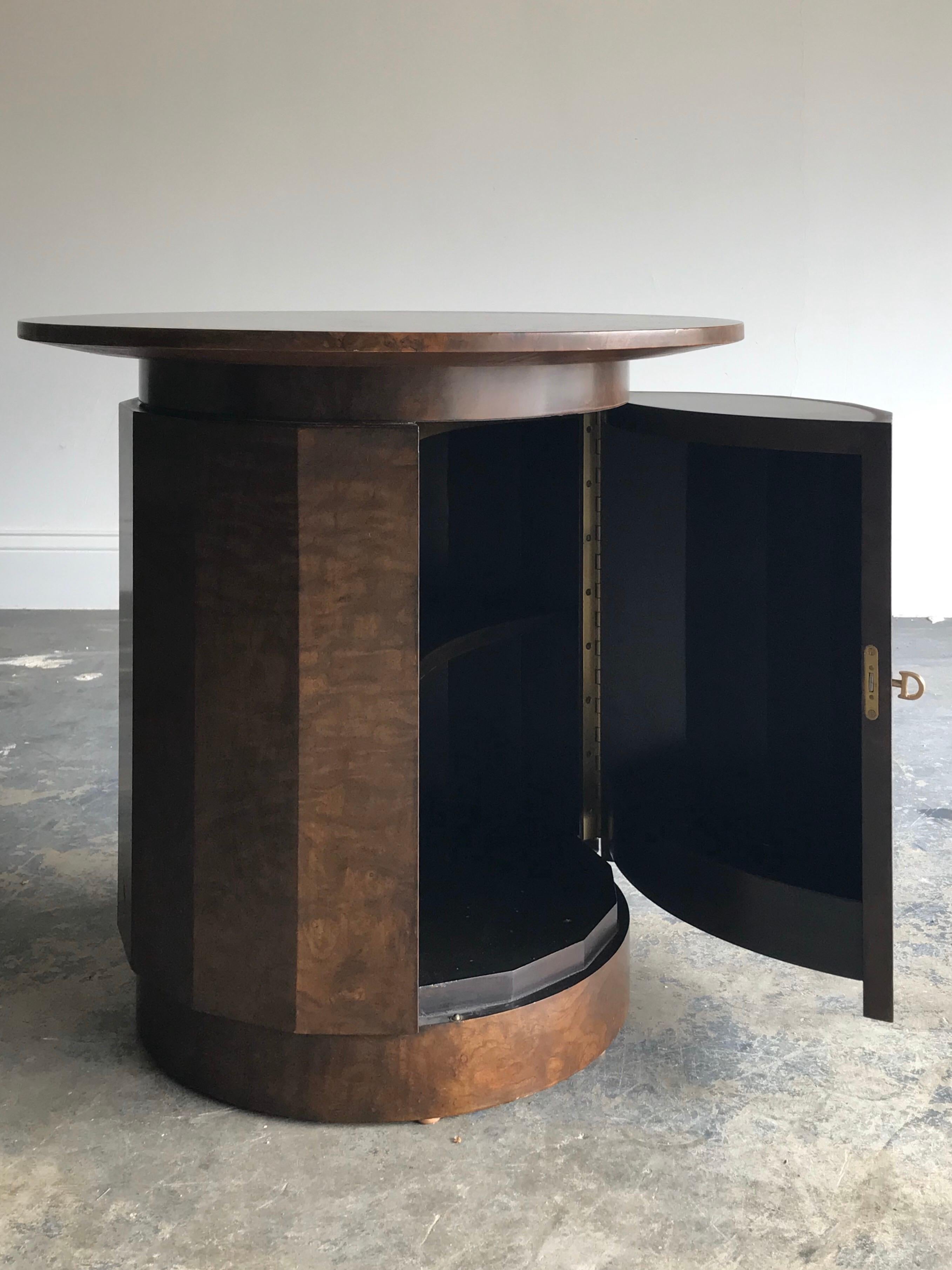 Custom Dunbar table designed by Edward Wormley. Featuring a faceted front with locking door. Inside reveals an adjustable height shelf, and the door has a storage cubby, ideal for a dry bar. Table was offered with a round top the size of the base,