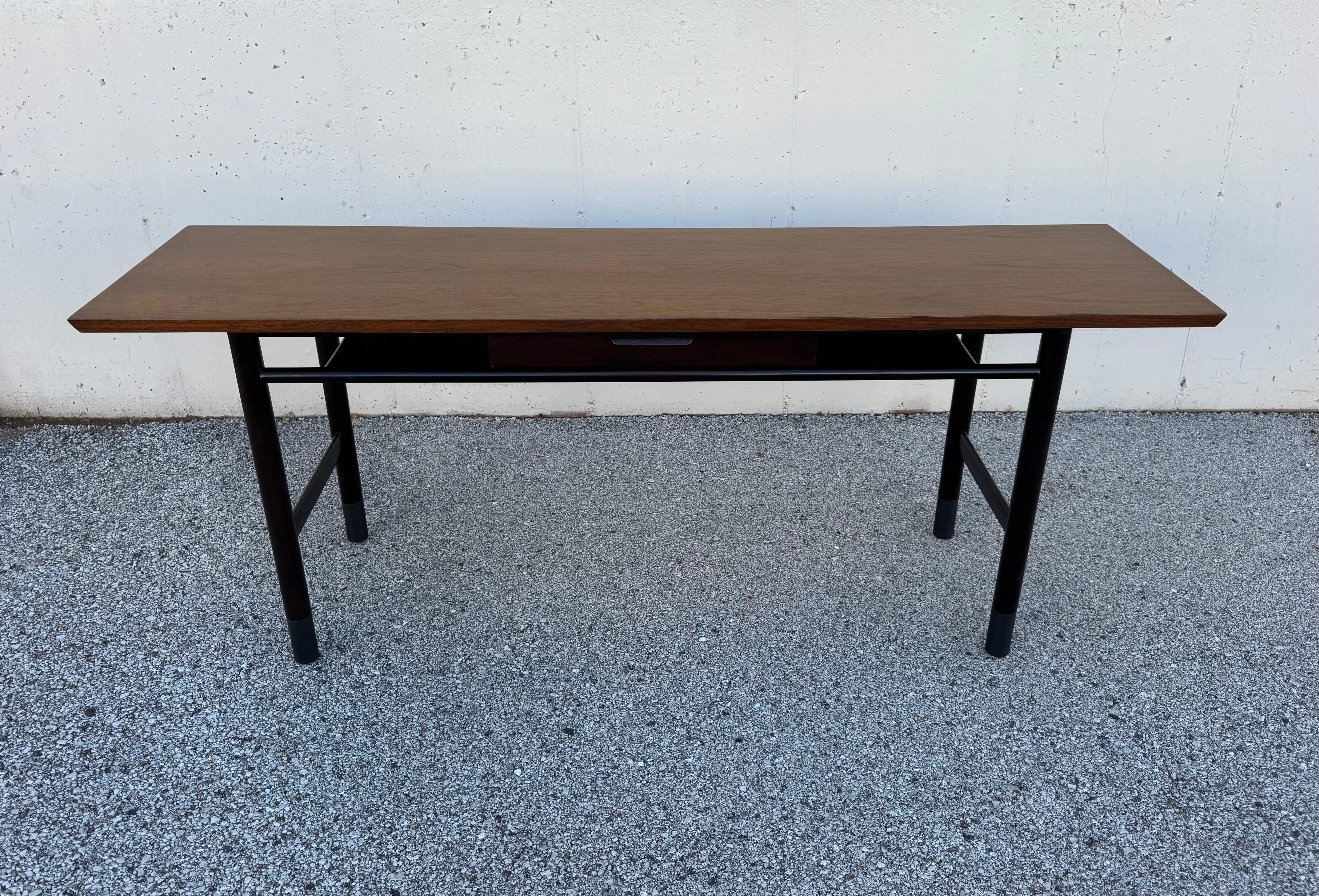 Elegant Mid-Century Modern Edward Wormley for Dunbar model # 5294 two level console or sofa table with centered single drawer. Professionally refinished, in two-tone to match original, book matched walnut top on a mahogany base with black leather