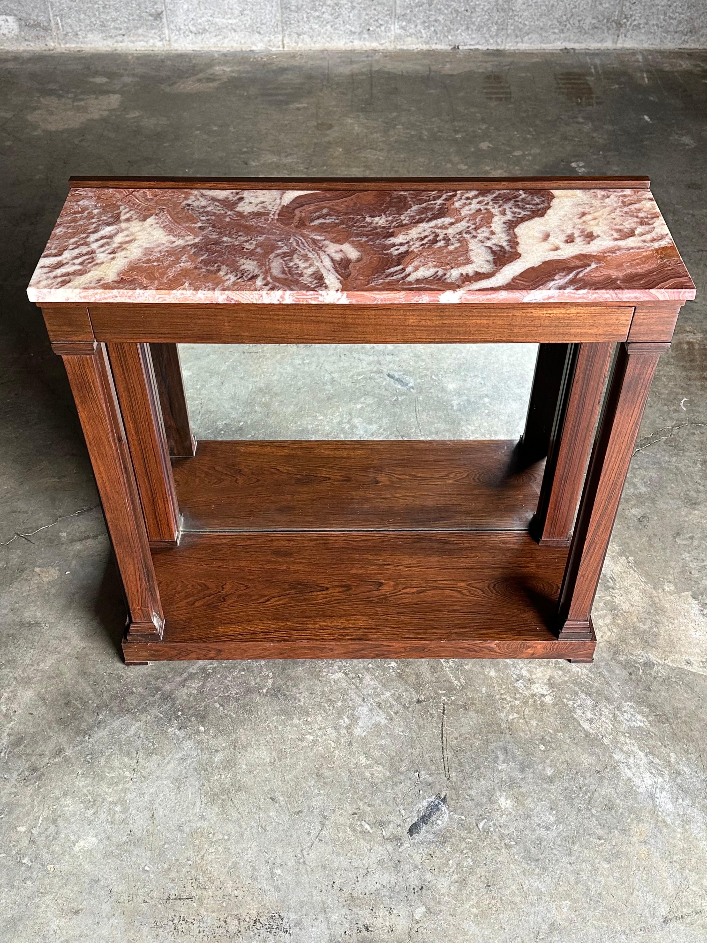 A rare console table designed by Edward Wormley for Dunbar Furniture. The table features traditional design elements that are so often seen in many of his pieces along with Dunbar’s top tier build quality. Piece features a mirrored back, squared off