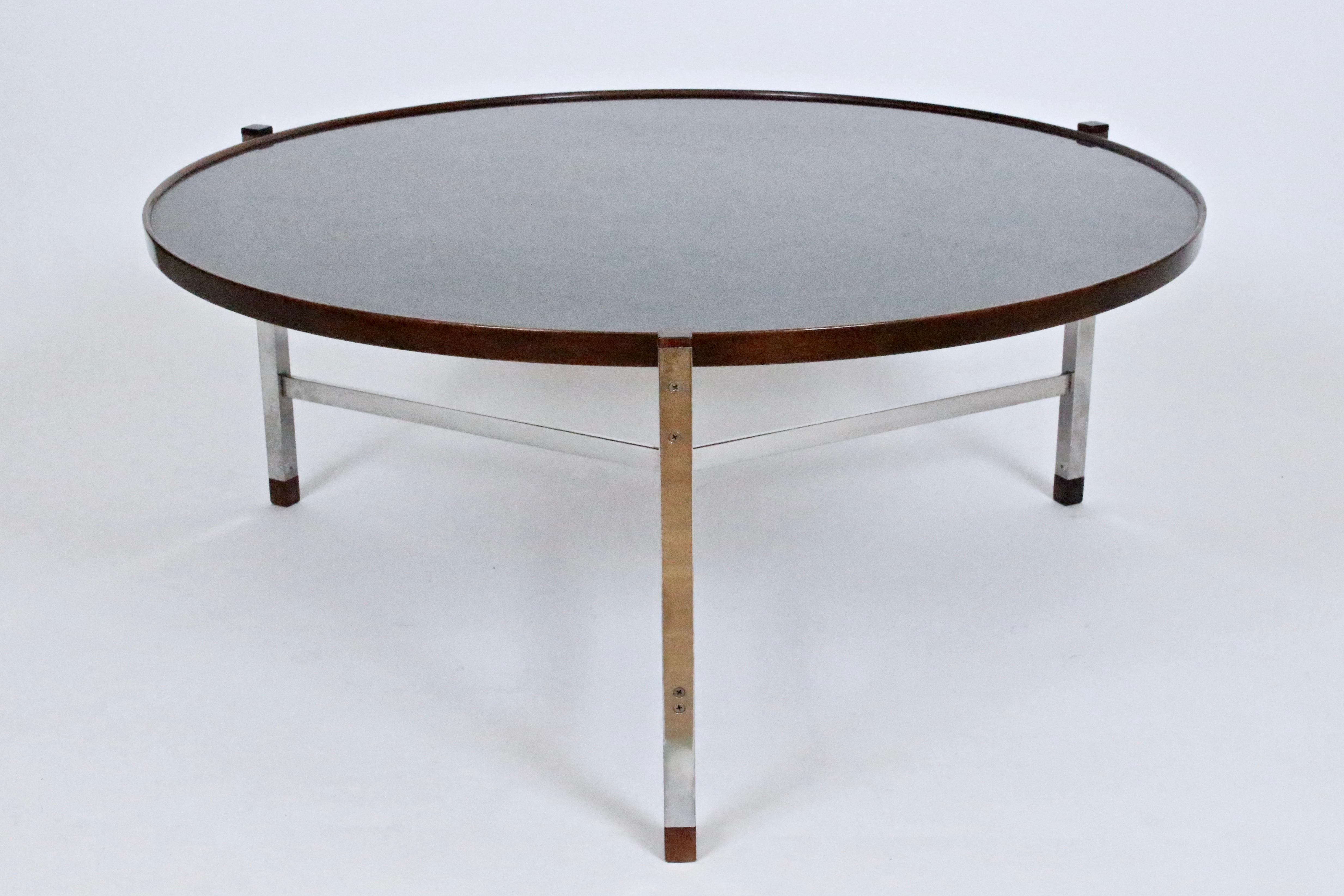 Edward Wormley for Dunbar chrome, rosewood surround and black laminate round coffee table. Featuring braced solid steel cross bars, squared chrome legs, rosewood cap and foot detail, lipped rosewood surround, inset with reflective (40D) Black