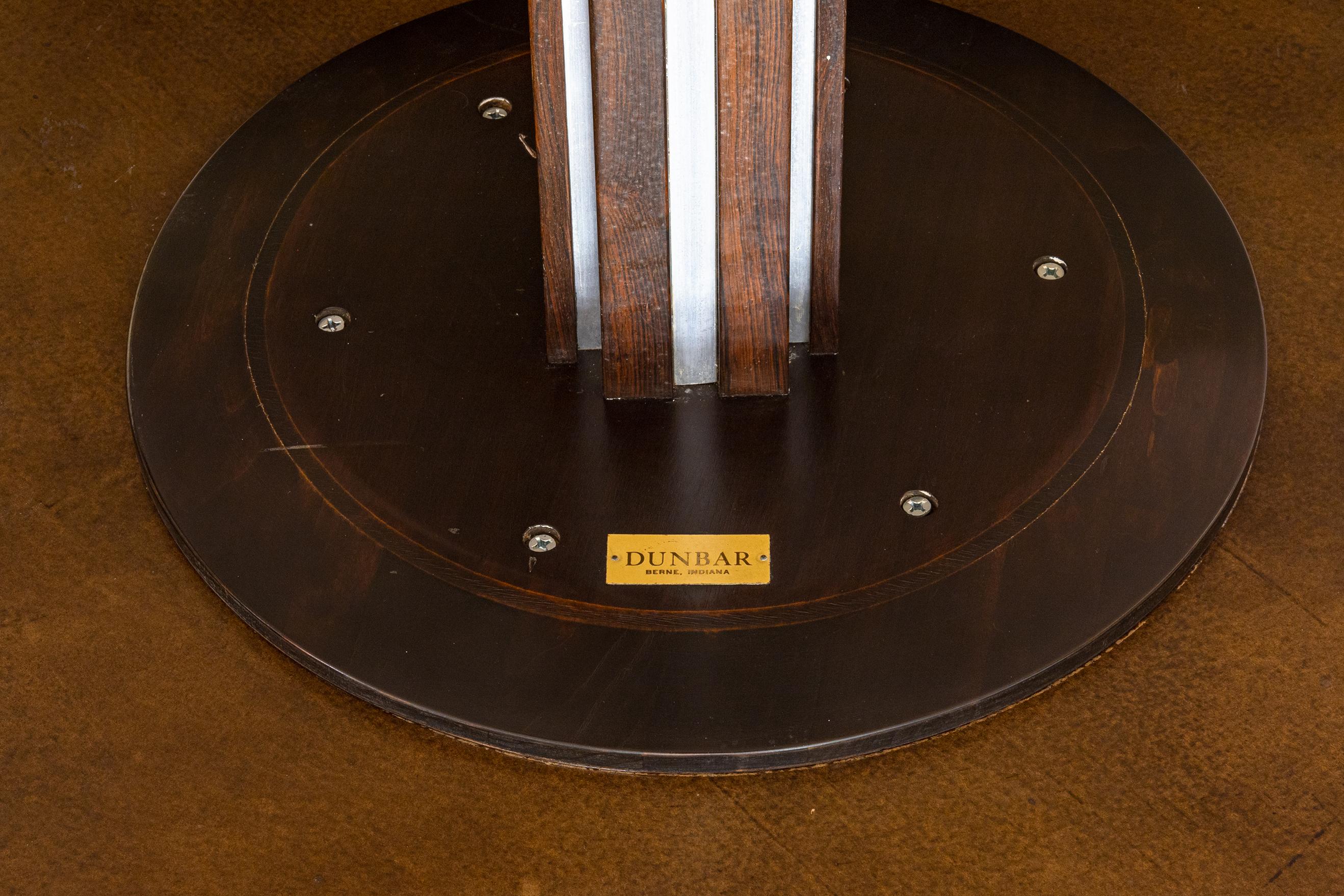 An Edward Wormley for Dunbar round rosewood and chrome dining table with black formica top. An elegant round table designed by Edward Wormley for Dunbar. Circa 1960. Black high polish Formica top. The pedestal base is made of rosewood with recessed