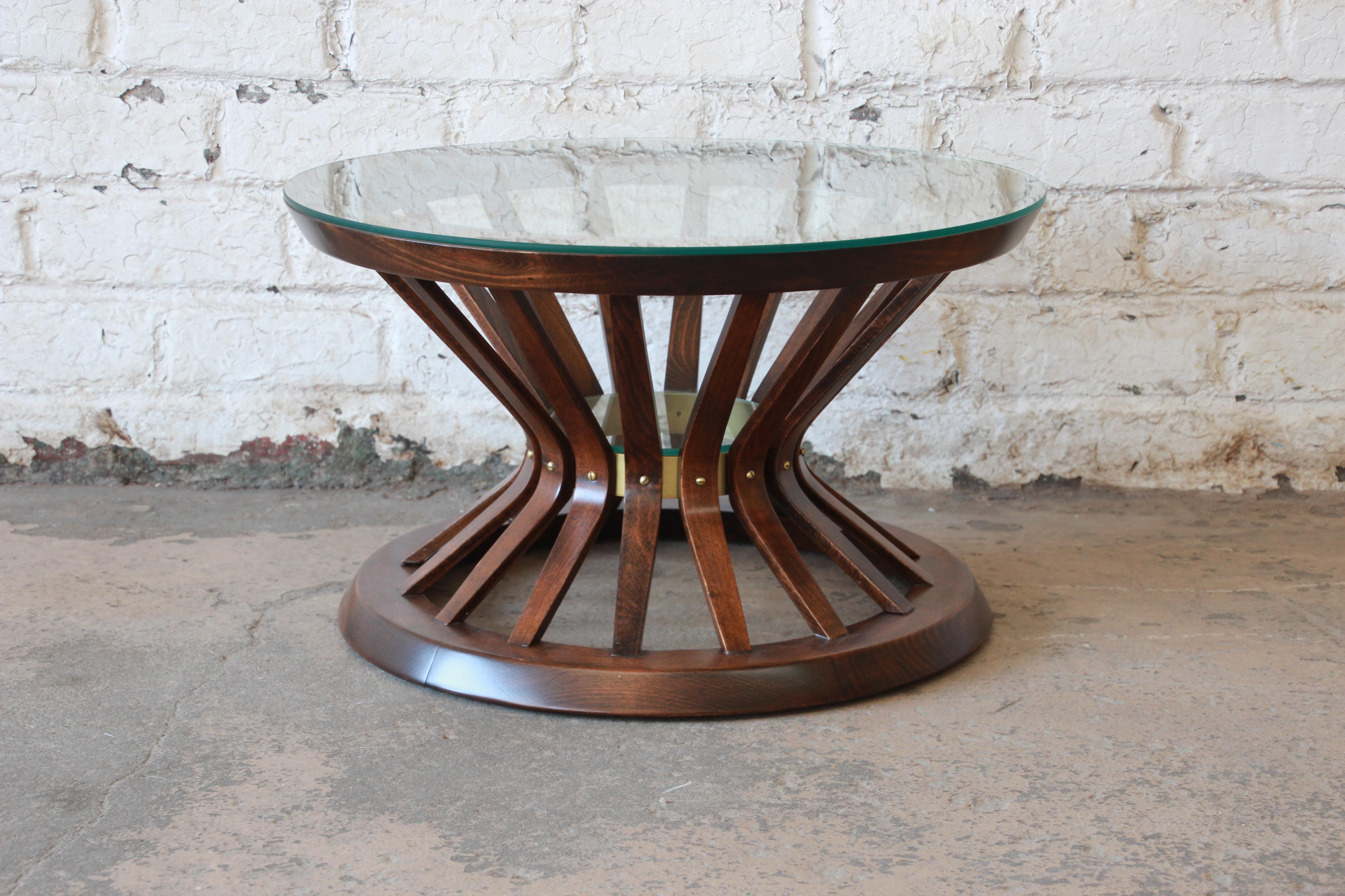 A stunning sheaf of wheat cocktail or occasional table designed by Edward Wormley for Dunbar. The table features a gorgeous walnut base, with brass accent, and a round glass top. The base has been professionally refinished and is in excellent
