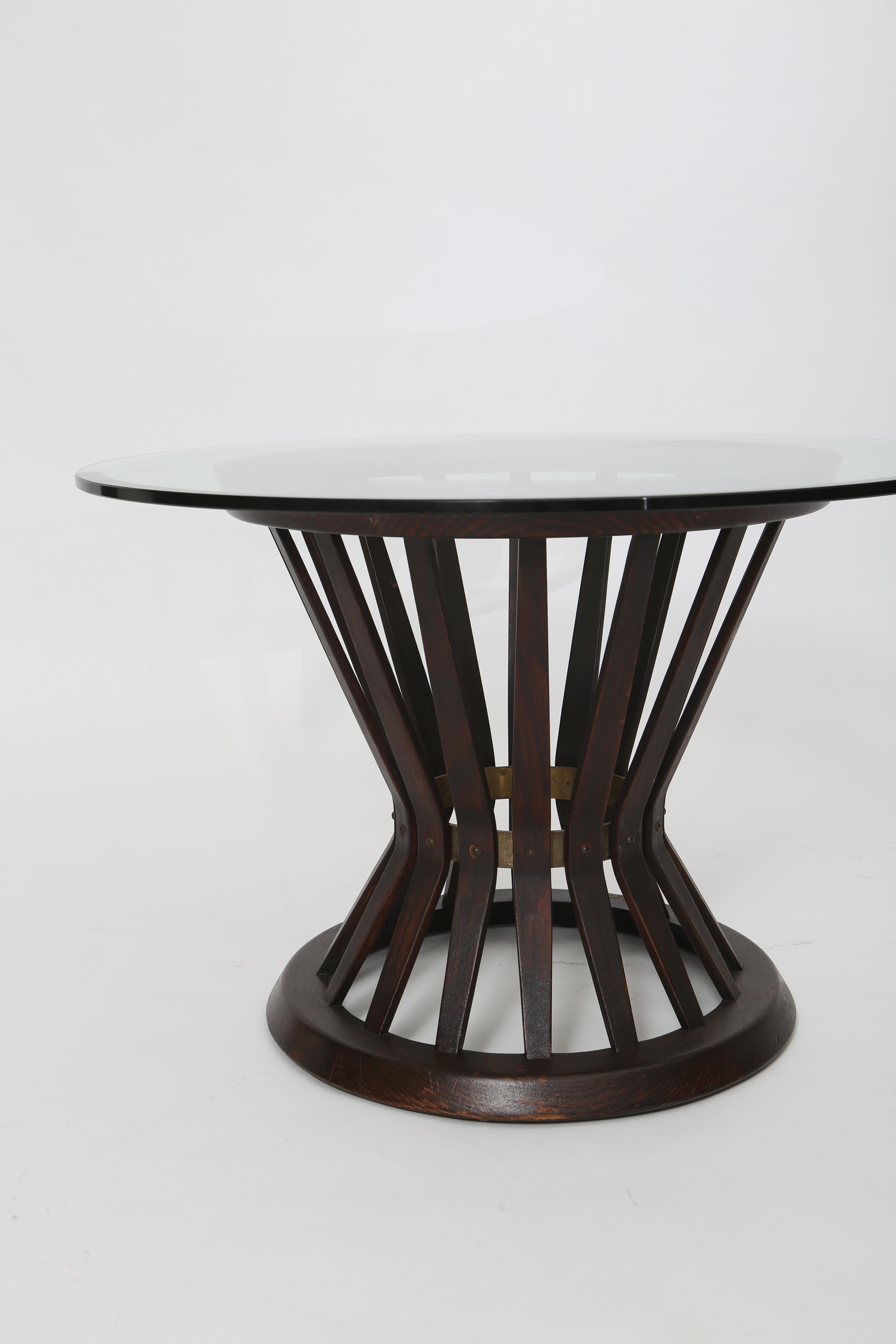 “Sheaf of Wheat” side table with glass top by Edward Wormley for Dunbar. Dark-stained oak vertical slats bend and taper at center; accented by a ring of lovely patinated brass. Original finish shows signs of age and use. Glass top 1/2” thick with