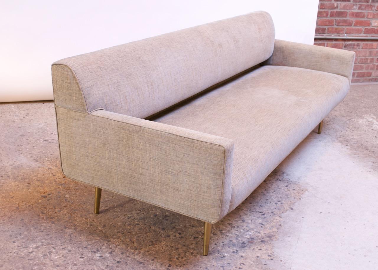 1950s Edward Wormley for Dunbar sofa on brass, tapered legs. The section under the backrest is recessed. Recently restored and reupholstered (last two years). However, there are two patches of slight discoloration to the right back and left back