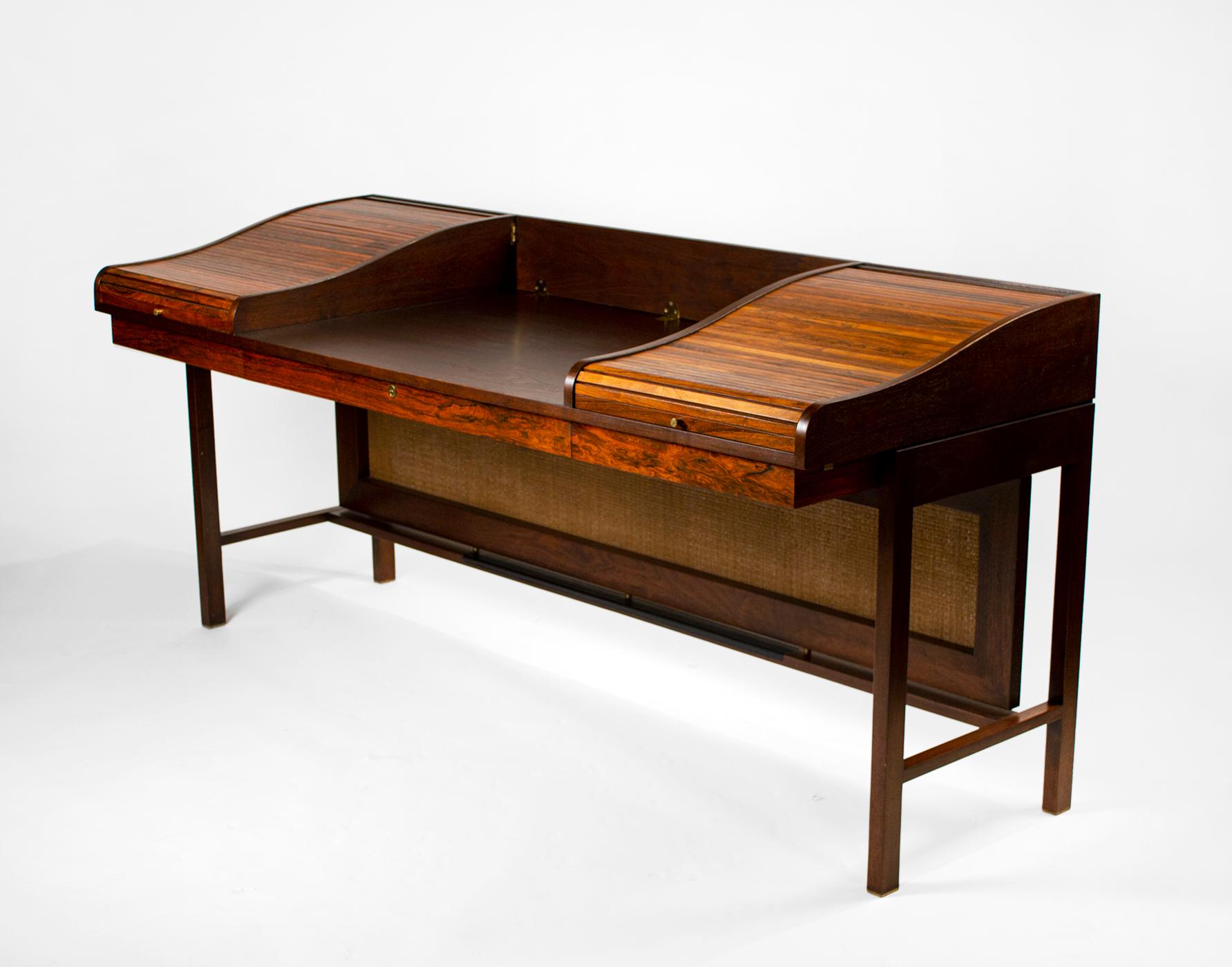 This rare beauty was designed to keep your office space uncluttered. The body of the desk is crafted from American walnut, the tambours are solid Brazilian rosewood and the sabots are solid brass. The bottom stretcher has an inset of black leather.