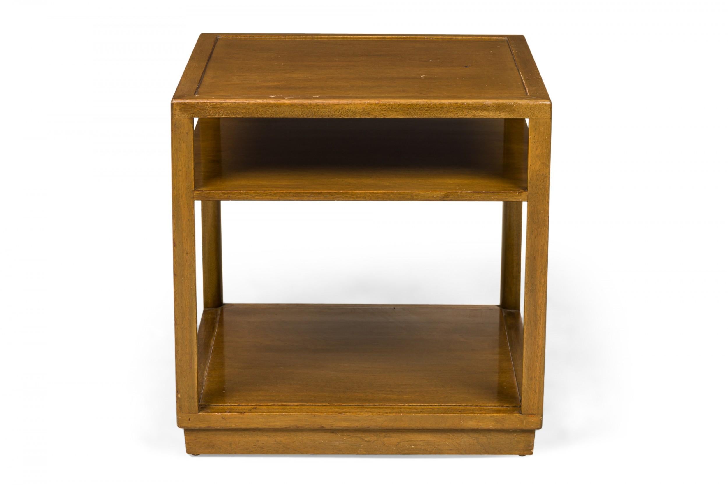 American Mid-Century square lacquered wooden end / side table with an open shelf below the square top, resting on a solid stepped base that creates as a taller lower shelf. (EDWARD WORMLEY FOR DUNBAR FURNITURE COMPANY)(Similar tables: DUF0648,