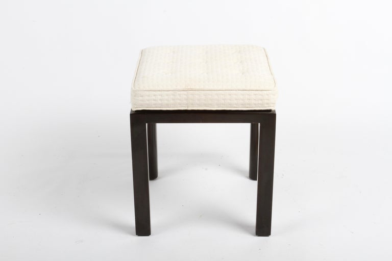 Mid-Century Modern Edward Wormley for Dunbar Stool or ottoman. This elegant stool has dark mahogany parson legs with an inside radius and original off white tufted upholstery. Original finish has minor scuffs, unrestored, minor stains to upholstery.