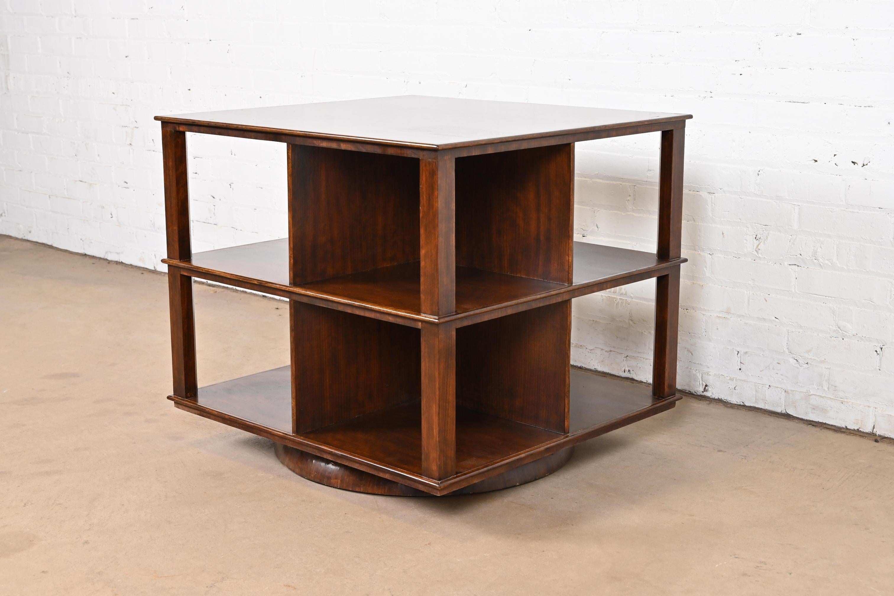 An exceptional Mid-Century Modern or Arts & Crafts revolving bookcase table

In the manner of Edward Wormley for Dunbar Furniture

USA, Circa 1950s

Measures: 30