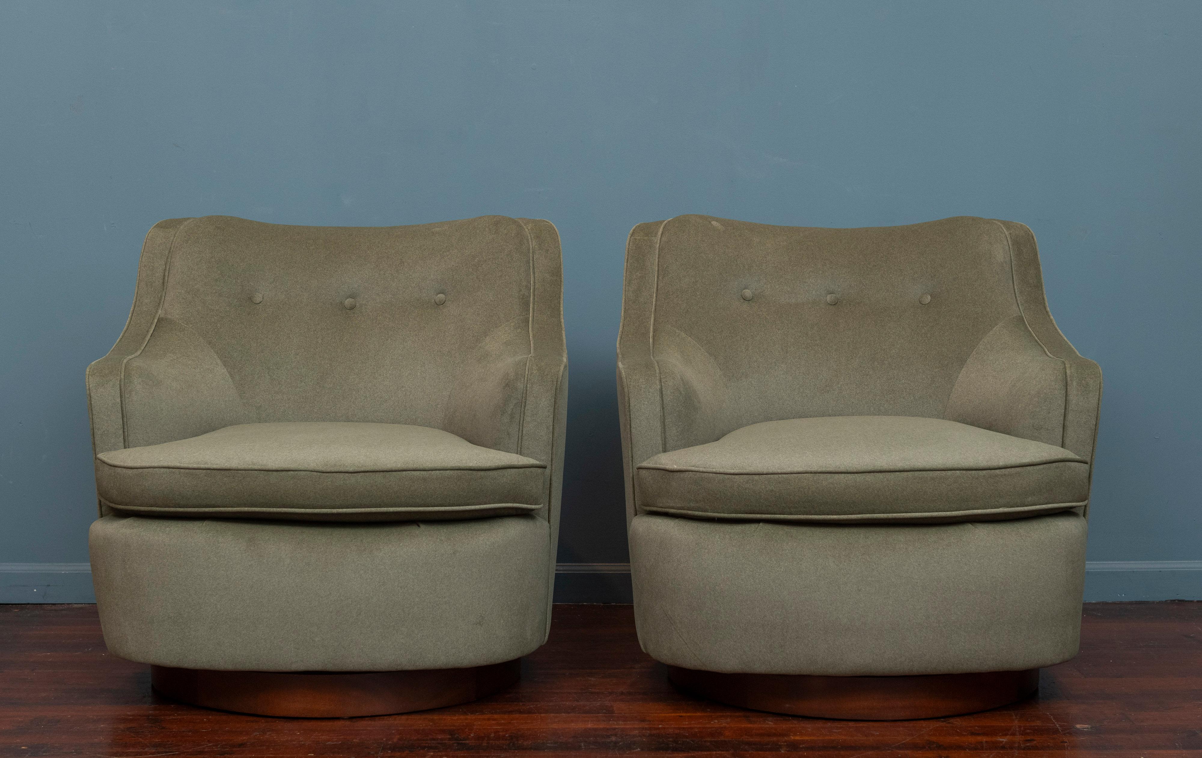 Edward Wormley for Dunbar Furniture swivel lounge chairs, model 4626. Large comfortable chairs with built in half rounded arms and a deep seat. Newly upholstered in a moss mohair or velvet upholstery that was very recently redone. Mahogany swivel