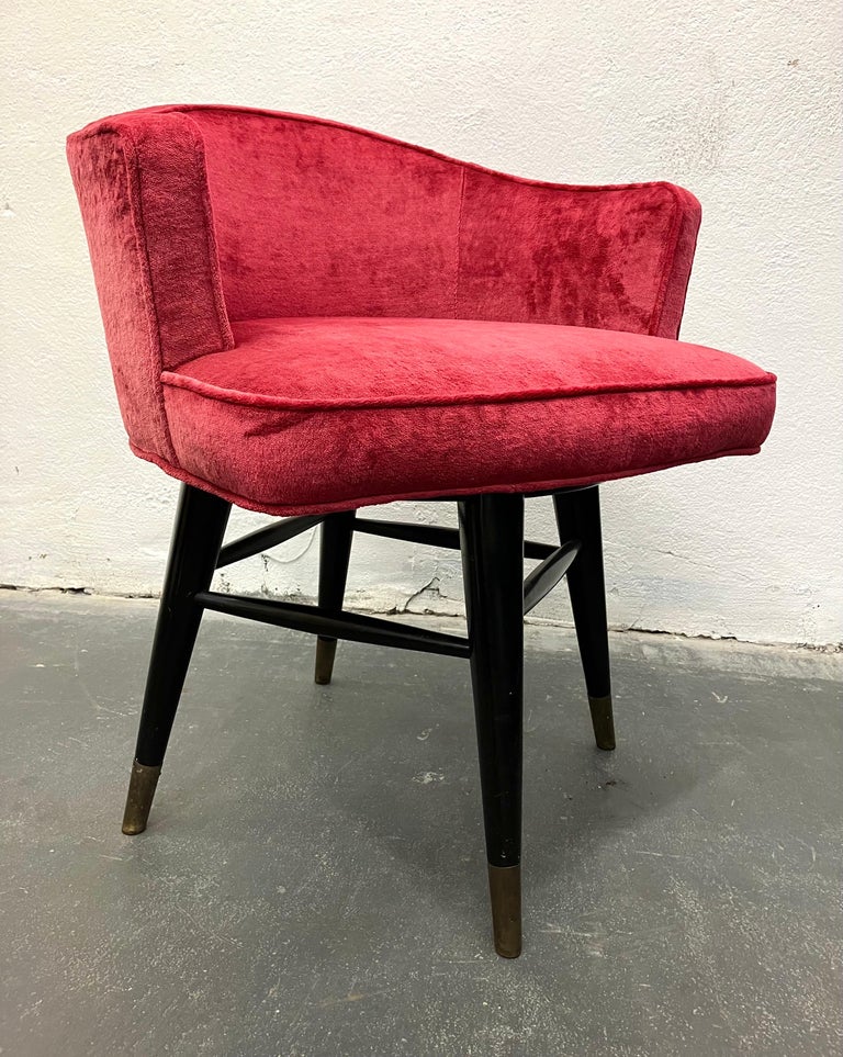 This sweet early Wormley modern design makes a perfect vanity or desk chair. The fully upholstered seat swivels over dark stained mahogany legs joined by dowel stretches, with capped brass feet. Unlabeled but well documented.