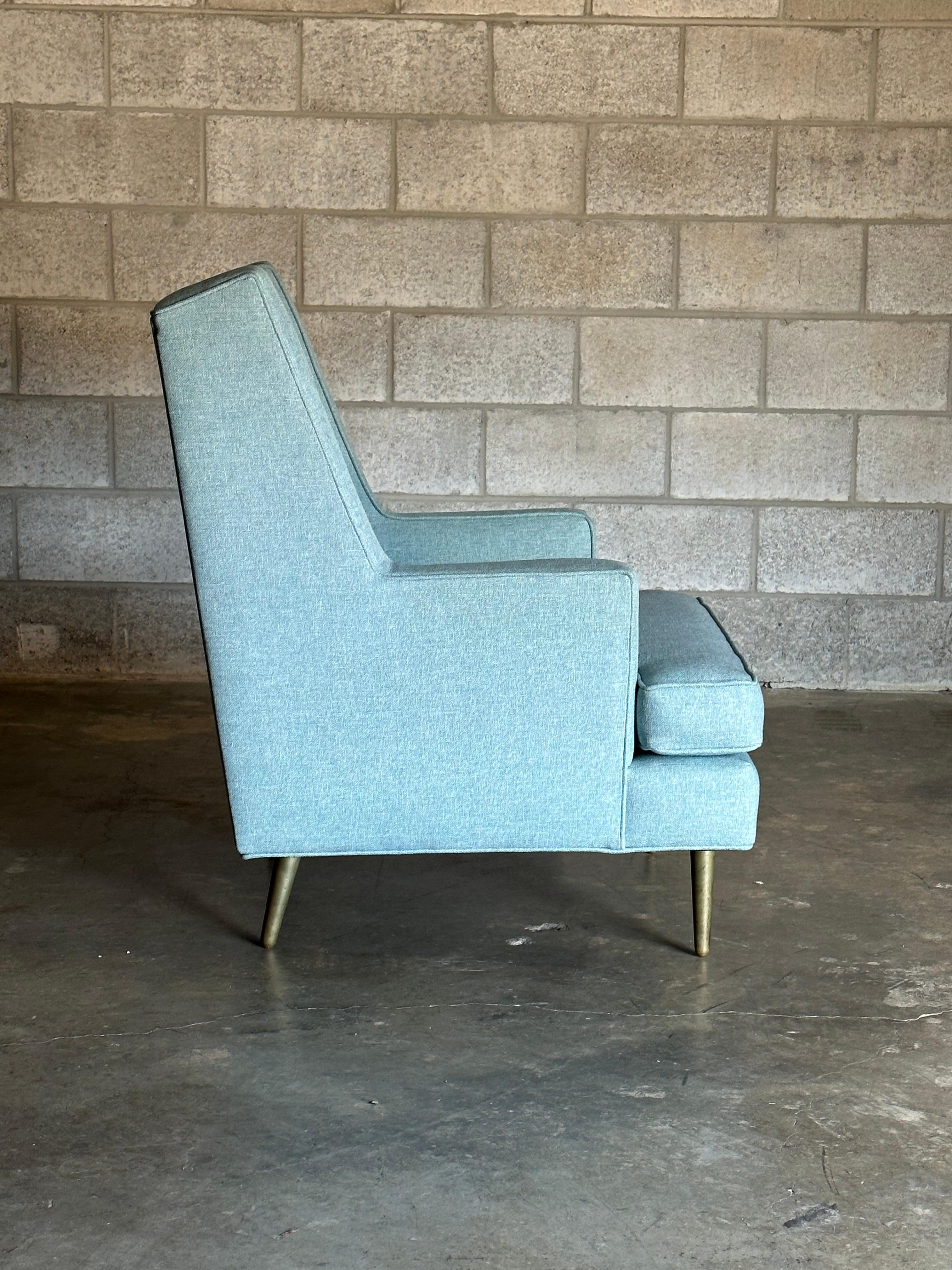 An oversized modernist take on an iconic wingback chair by iconic designer Edward Wormley for Dunbar. Features a well proportioned frame with tall seat back over solid patinated brass legs. Superb construction that Dunbar is known for. Unmarked due
