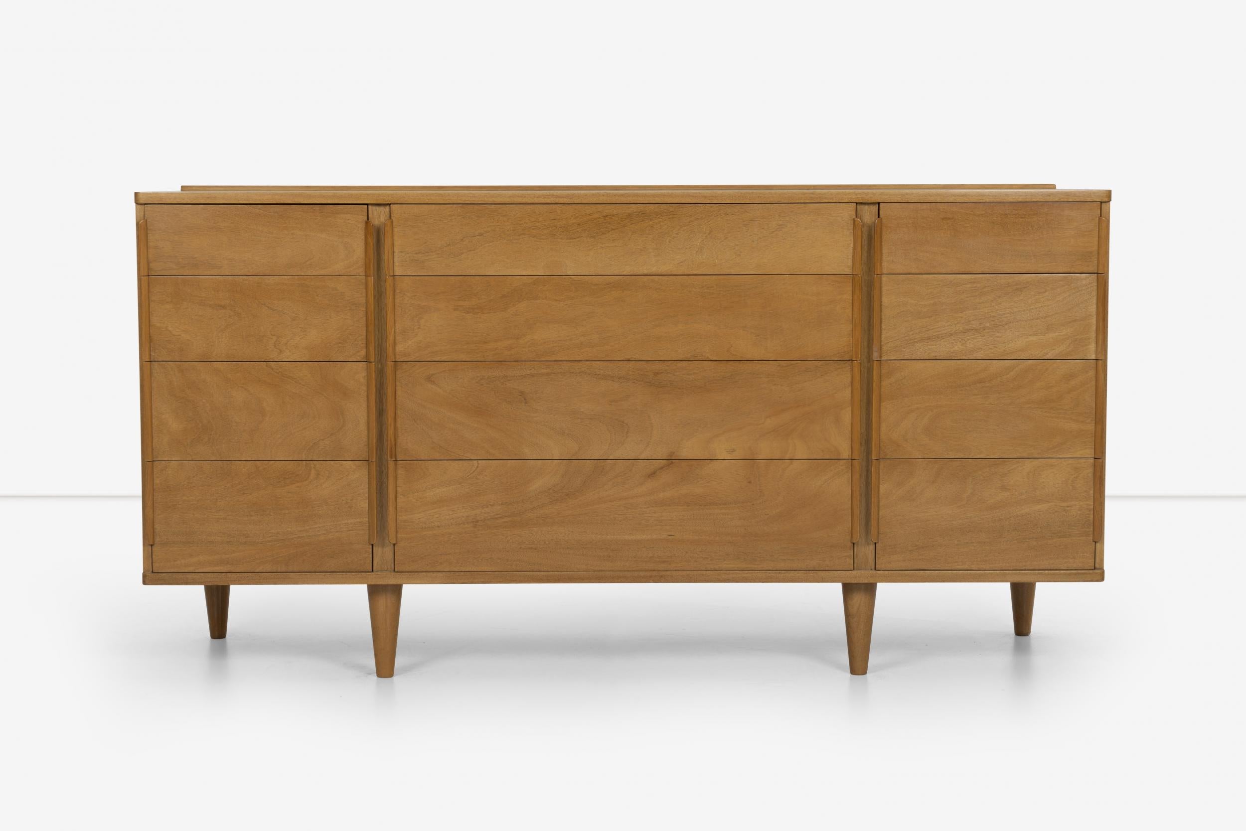 Edward Wormley for Dunbar triple dresser in mahogany wood,1952 Model 5272 features 12-drawer storage with solid turned tapered legs and curved pulls. 
Label inside drawer, [DUNBAR].






  