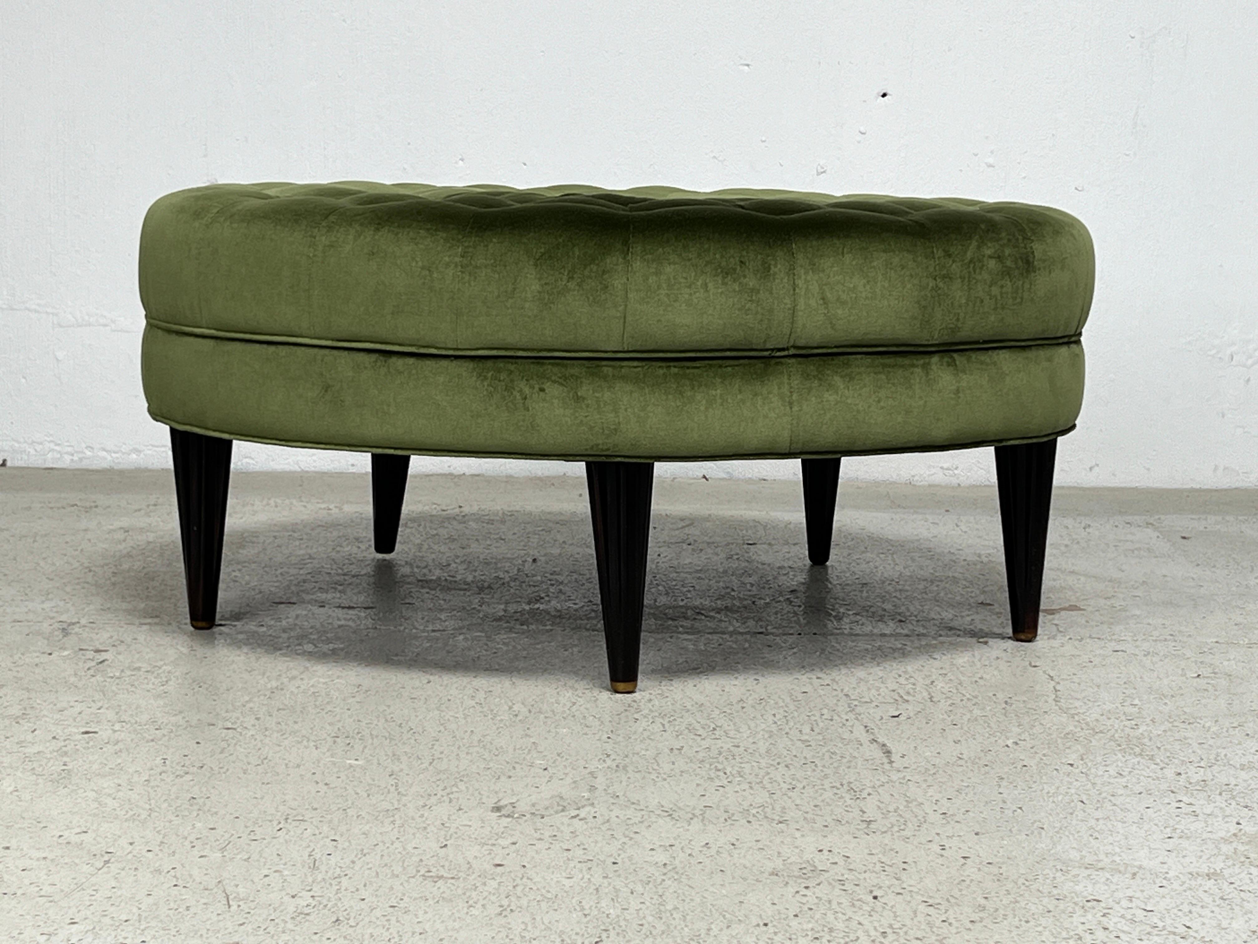 A rare tufted ottoman on fluted rosewood legs with brass feet. Designed by Edward Wormley for Dunbar. Reupholstered in green velvet. 