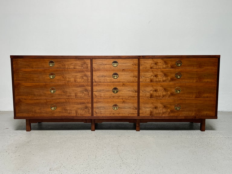 A rare cabinet designed by Edward Wormley for Dunbar. Twelve drawer walnut cabinet with exposed joinery and brass hardware with inset Brazilian rosewood from the Janus collection.