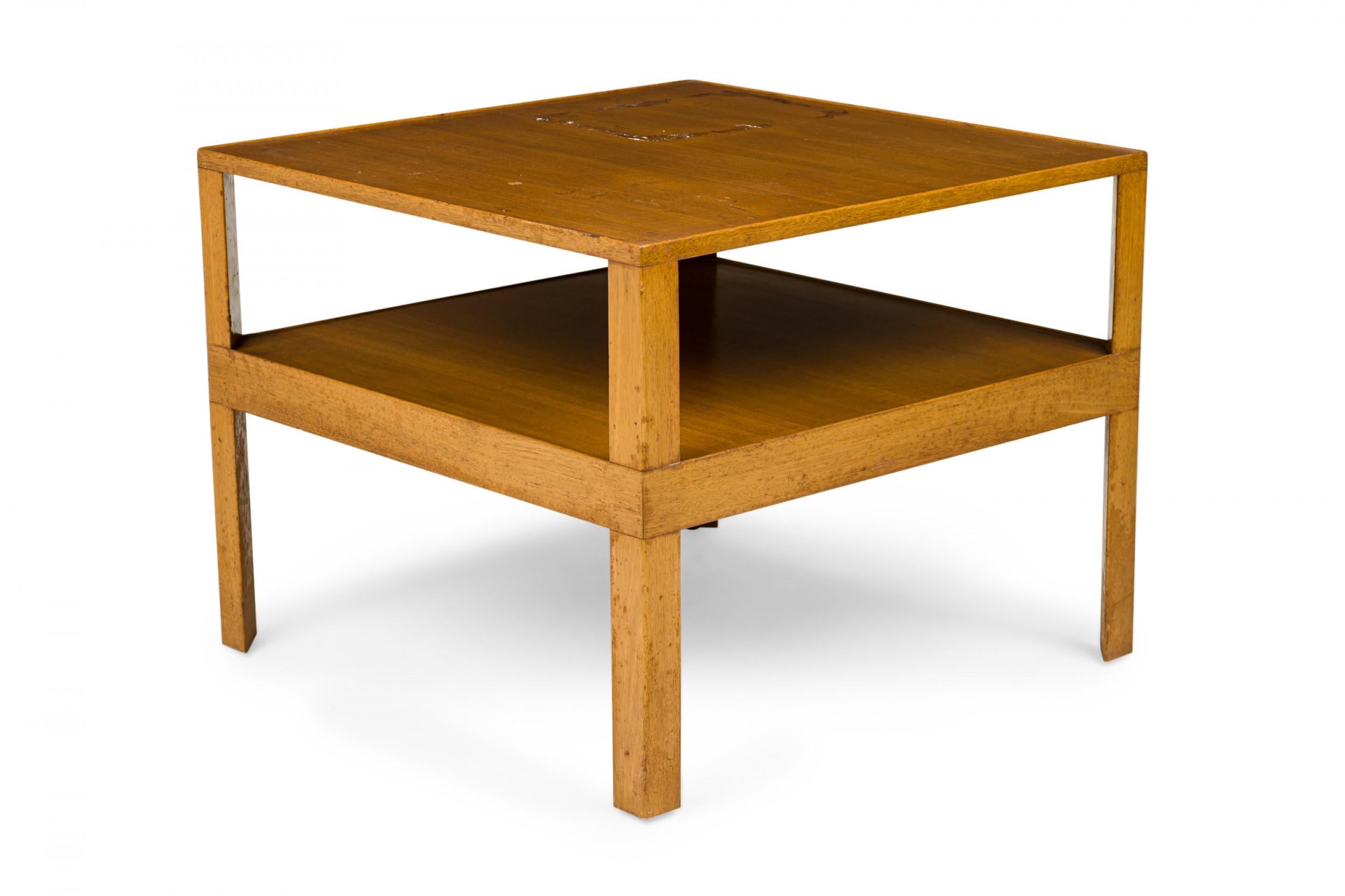 Table d'appoint en bois blond du milieu du siècle dernier, à deux niveaux, avec un plateau carré et une étagère inférieure soutenue par quatre pieds triangulaires. (EDWARD WORMLEY POUR LA SOCIÉTÉ DE MEUBLES DUNBAR)

Éraflures et rayures