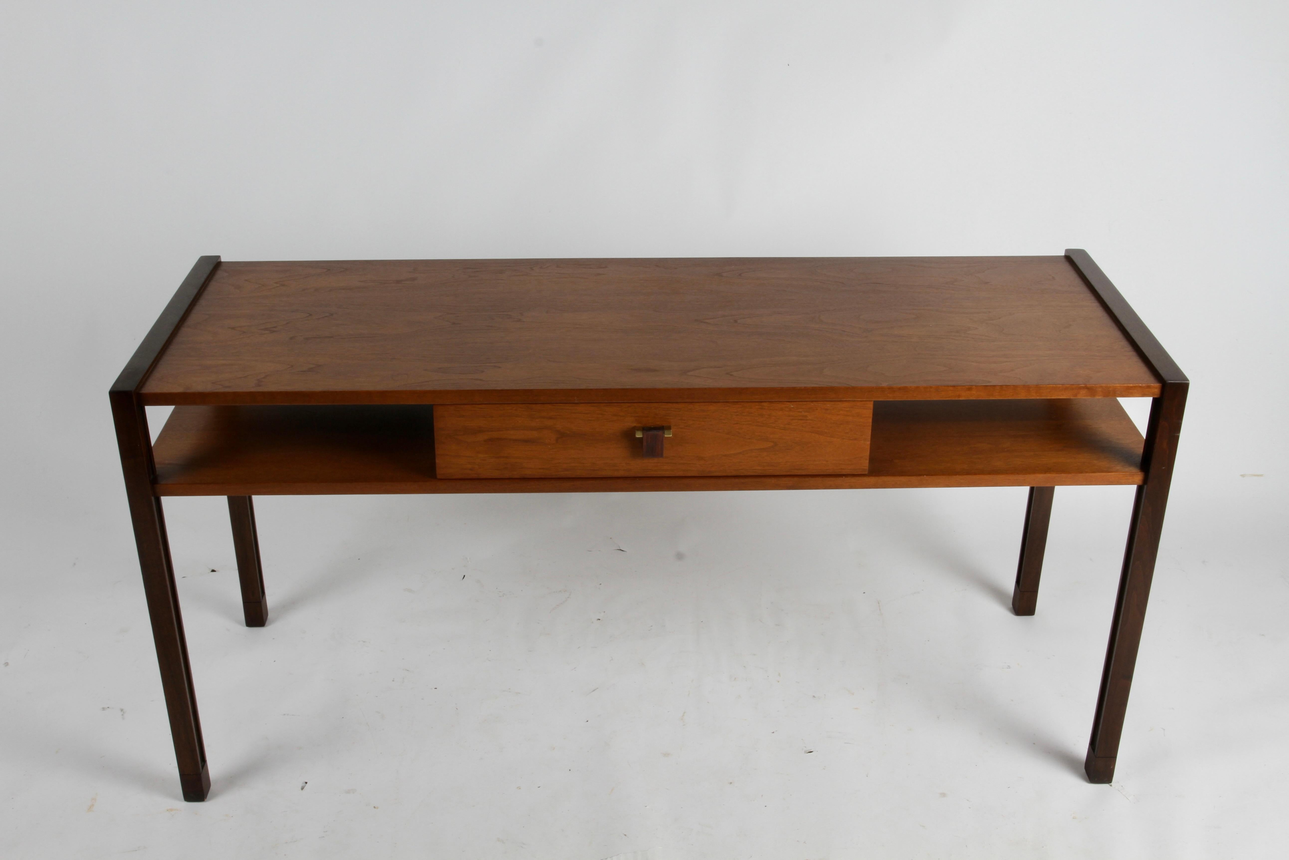 Elegant Mid-Century Modern Edward Wormley for Dunbar two level console or sofa table with centered single drawer in two-tone walnut. Supported on Parsons style legs, accented with subtle inset reveal. Single center drawer with carved rosewood drop