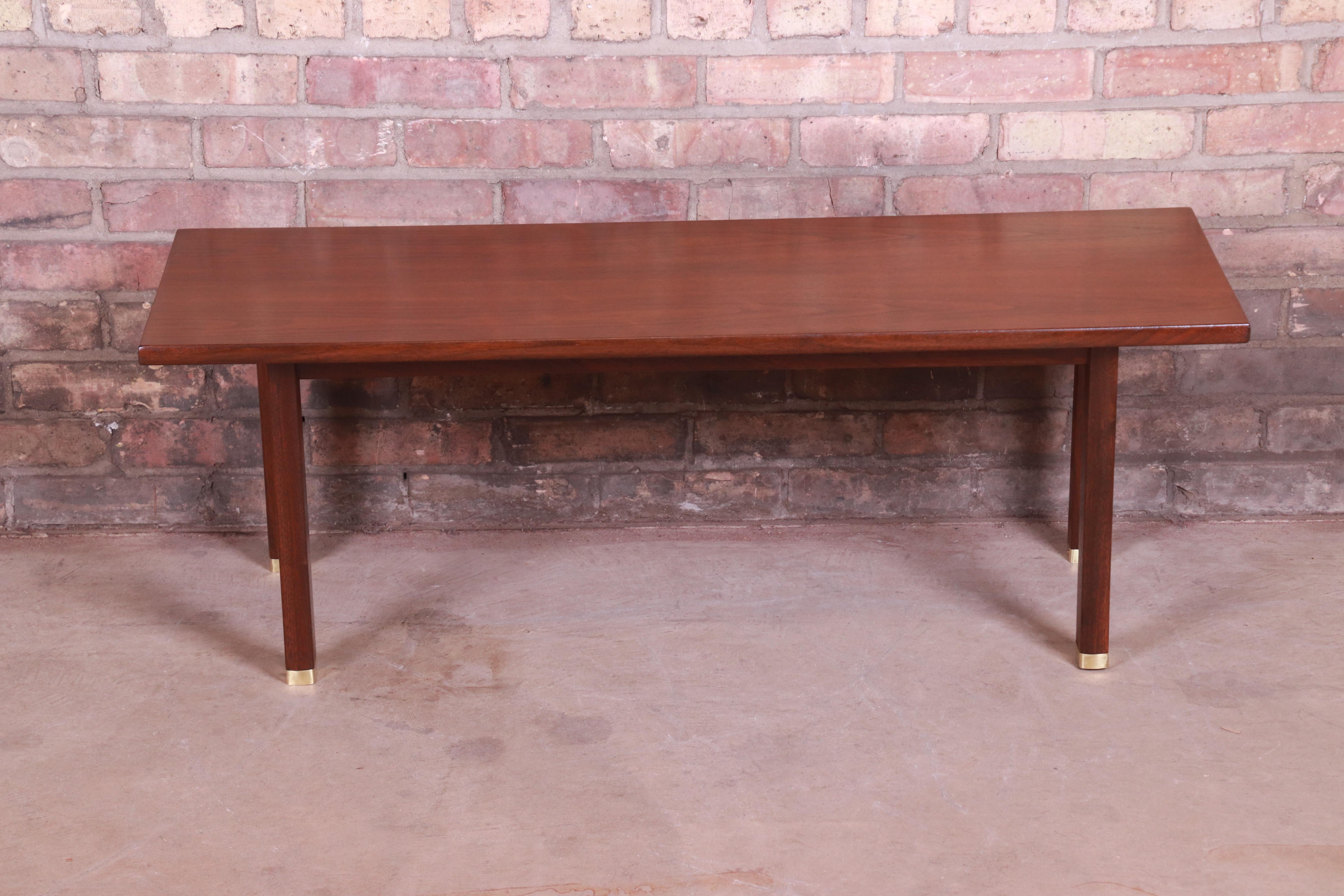 An exceptional Mid-Century Modern bench or coffee table

By Edward Wormley for Dunbar

USA, circa 1950s

Bookmatched walnut, with solid walnut legs and brass-capped feet.

Measures: 41.88