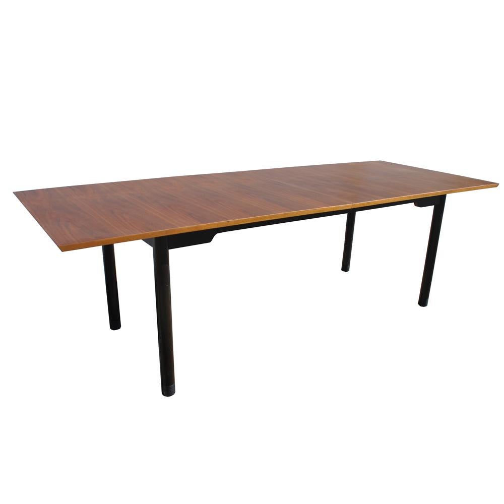 A stunning Edward Wormley walnut dining table with ebonized legs. Leather-wrapped feet.

Expands from 8ft to 13ft with the addition of four leaves. Drop down center support legs are easily stored underneath. 

Refinished.
 