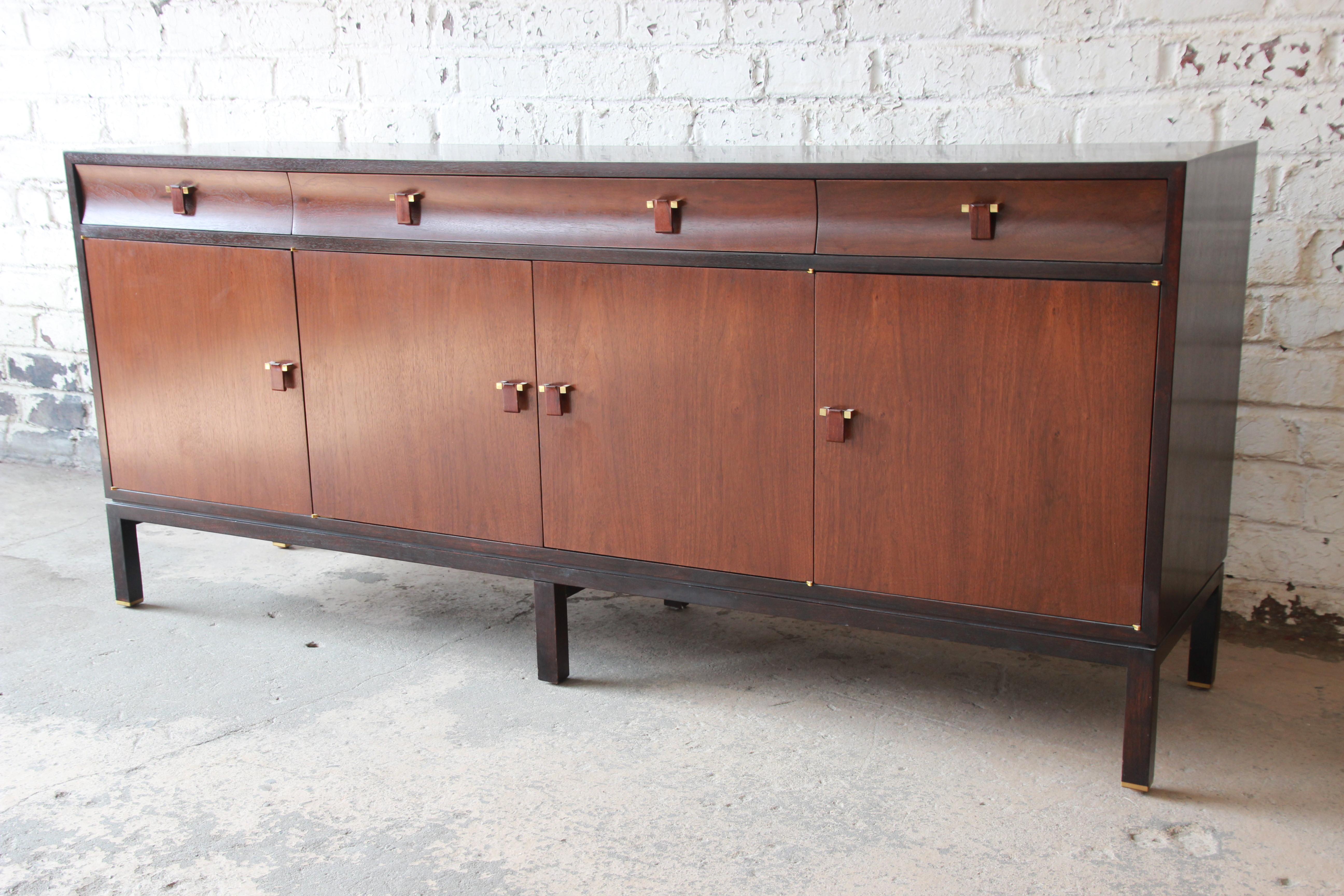 Offering an exceptional sideboard credenza by Edward Wormley for Dunbar. The unique statement piece features a great two-toned design with an ebonized case and walnut drawer and cabinet fronts. The pulls are also carved walnut adding to the elegant