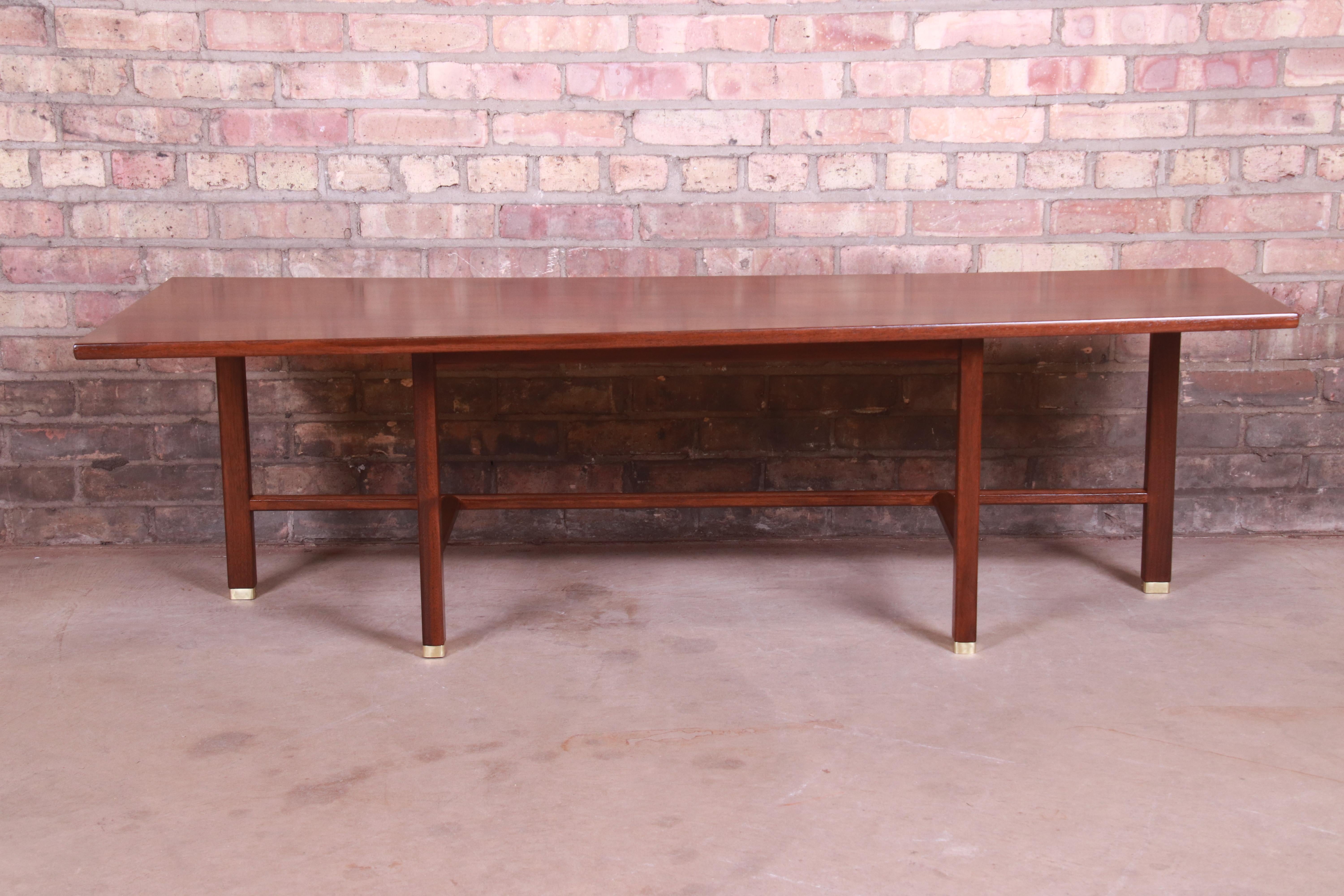 A unique Mid-Century Modern trapezoidal coffee table

By Edward Wormley for Dunbar

USA, circa 1950s

Bookmatched walnut, with solid walnut legs and stretchers and brass-capped feet.

Measures: 60