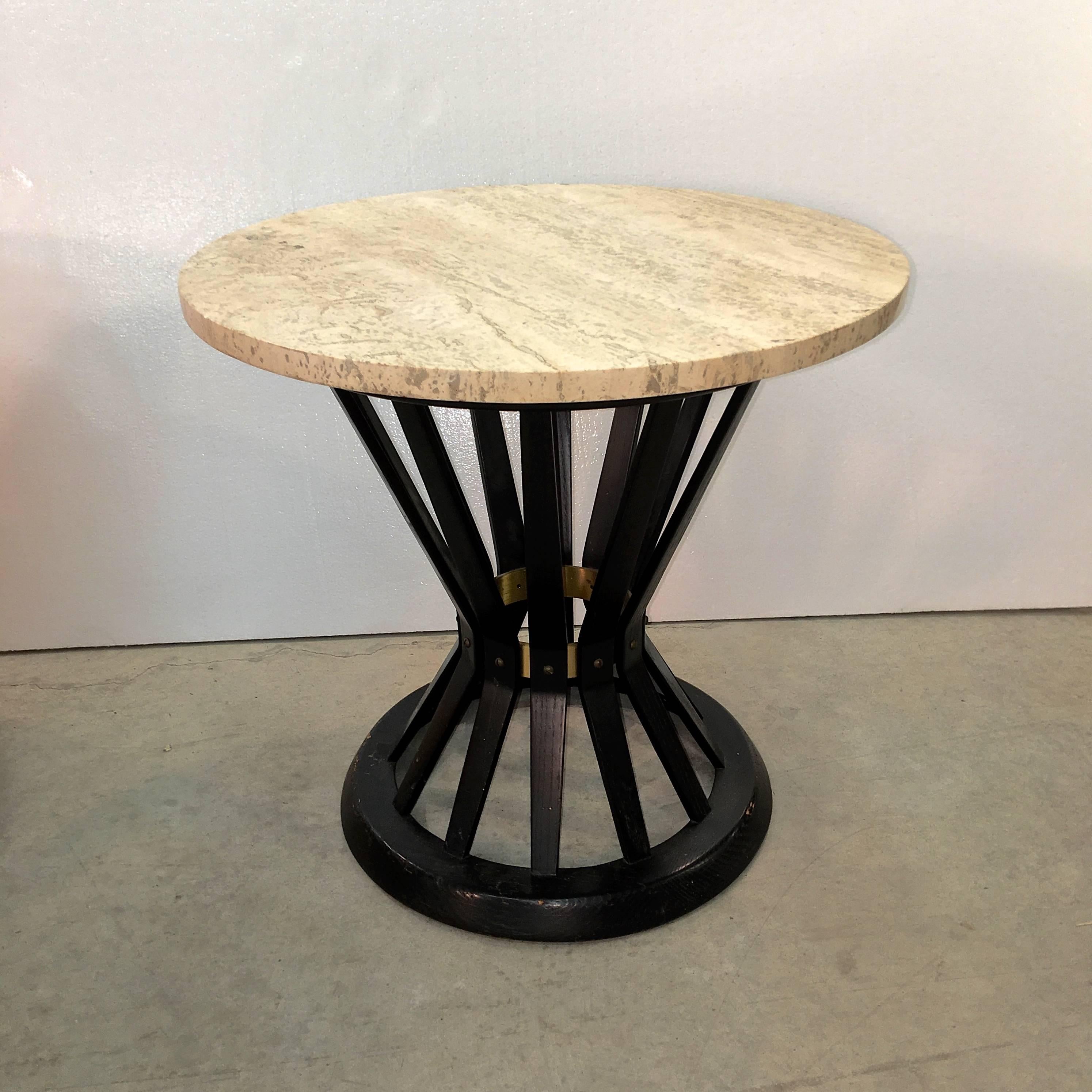 Travertine top round occasional table in the hourglass form of a bound sheaf of wheat with solid brass internal corset band with all original solid brass flat head screws. Original Dunbar metal tag present. Wood stain is original dark mahogany or