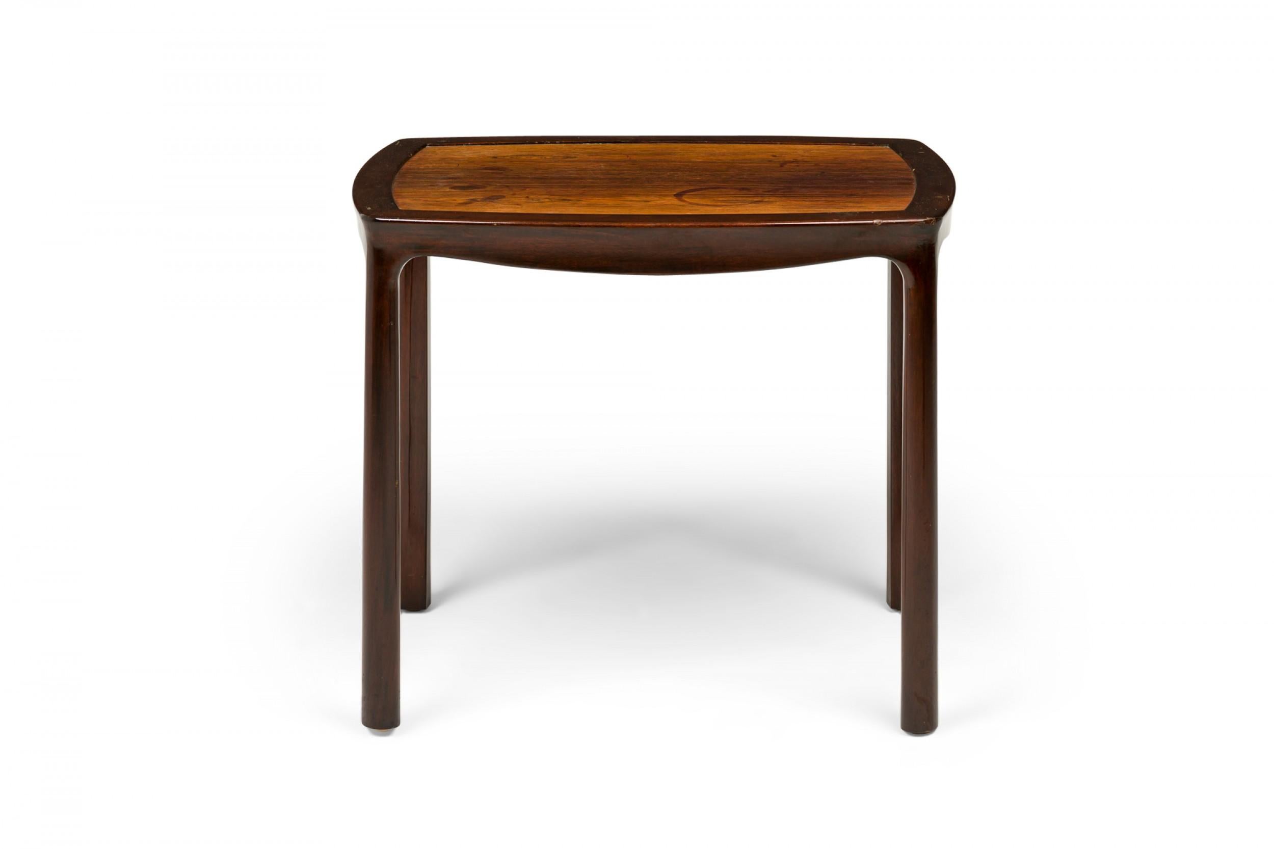 Table d'appoint / d'extrémité du milieu du siècle dernier avec un plateau rectangulaire légèrement arrondi et un plateau en bois inSet teinté plus clair soutenu par un cadre en bois plus foncé avec un tablier en forme et quatre pieds arrondis.