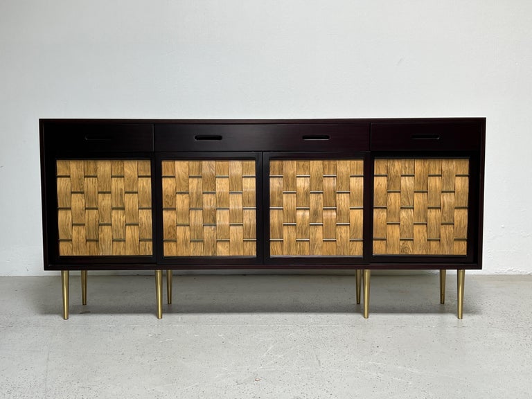 A large mahogany cabinet with woven bleached rosewood sliding doors on brass legs. Designed by Edward Wormley for Dunbar. 