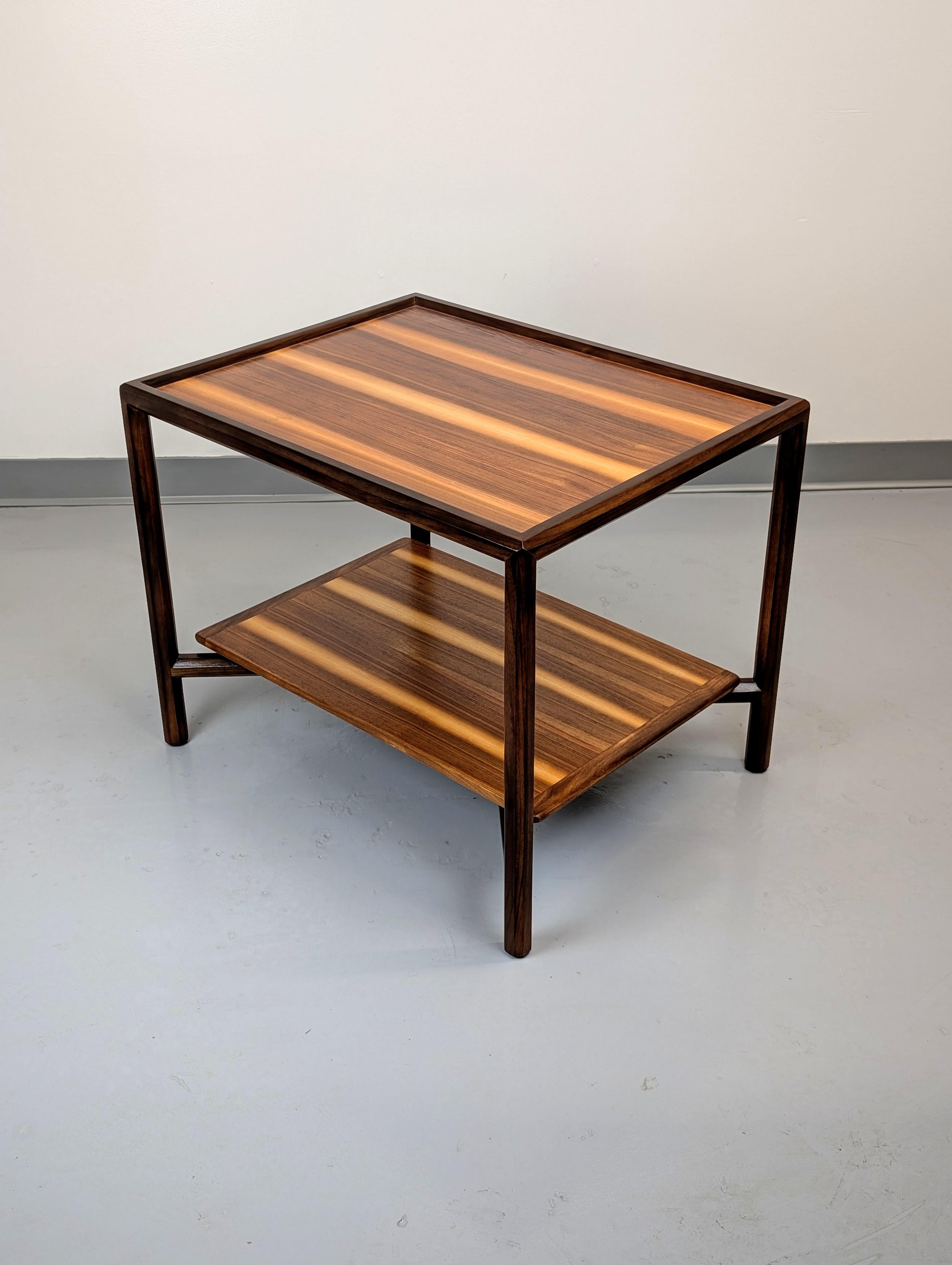 Table d'appoint Janus d'Edward Wormley pour Dunbar. Catalogué comme #5630  table. Grain et couleur remarquables. L'étagère inférieure est soutenue par de subtils supports en laiton. L'étiquette métallique de Dunbar est présente. Prêt à l'emploi. 