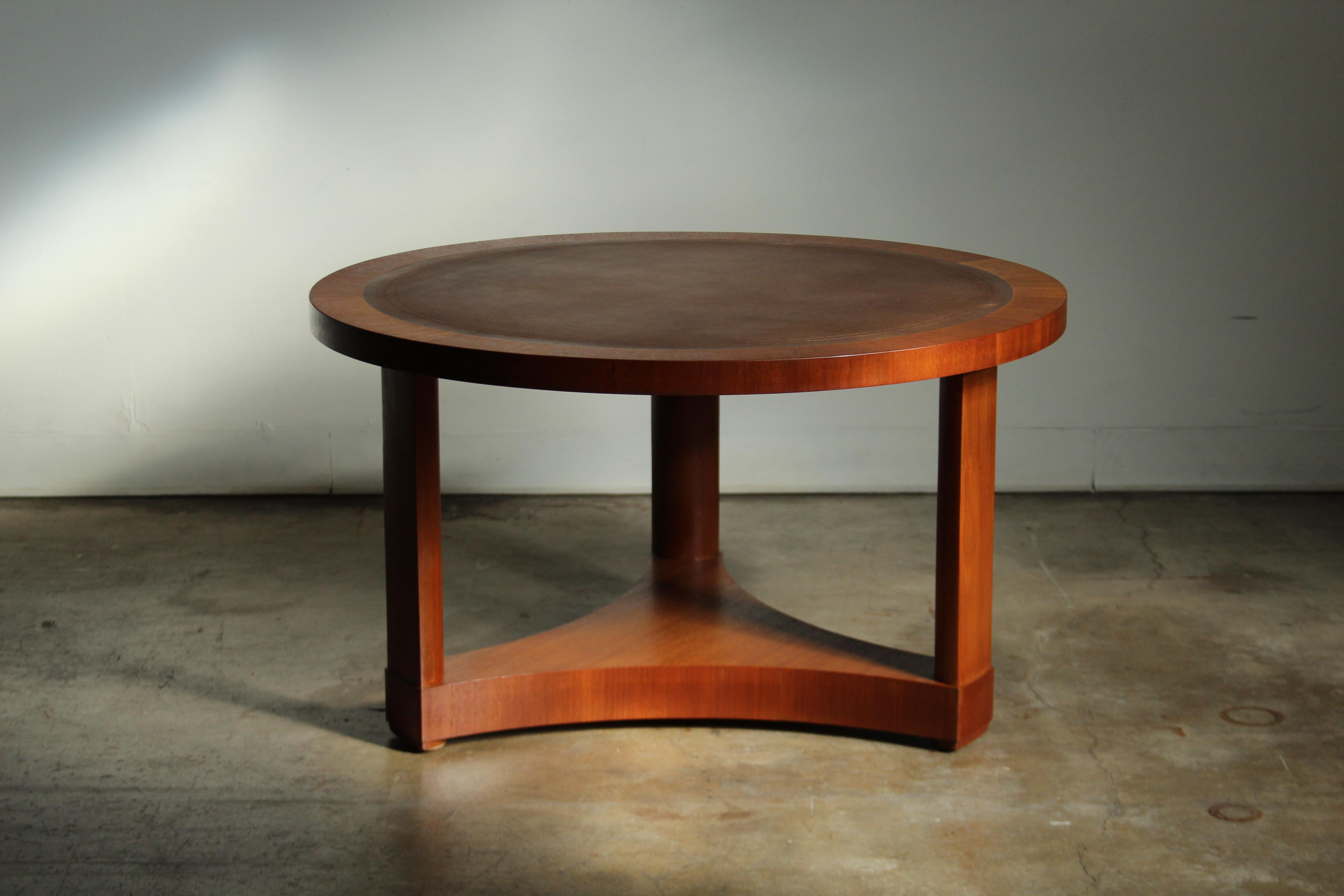 Table à cocktail de style Empire, conçue par Edward Wormley et produite par Dunbar au début des années 1950. La table est fabriquée en acajou avec un plateau en cuir. Cette table classique se fondra parfaitement dans une esthétique art déco ou