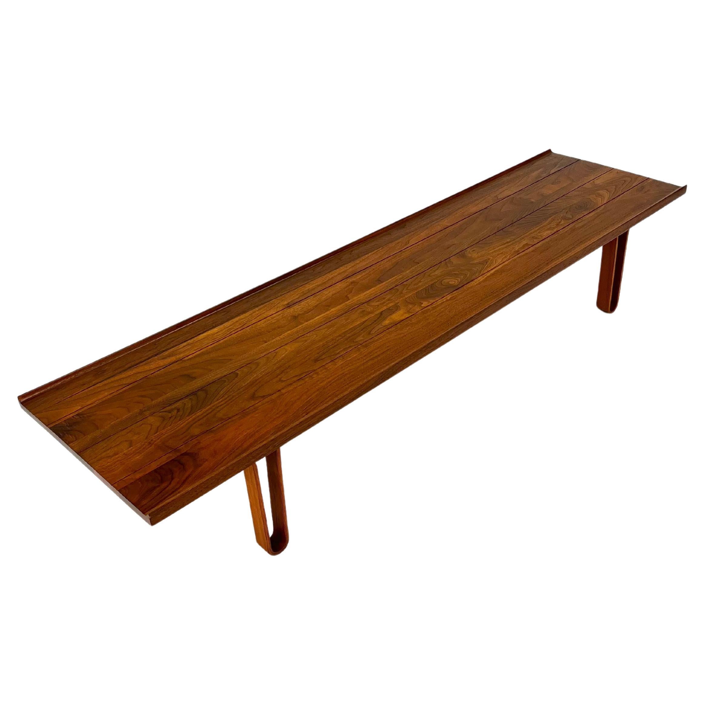 The iconic Long John bench designed by Edward Wormley for Dunbar. Features a solid walnut construction with bent hairpin plywood legs. The edge of the table has a slight raised edge. The table has been professionally refinished and is in excellent