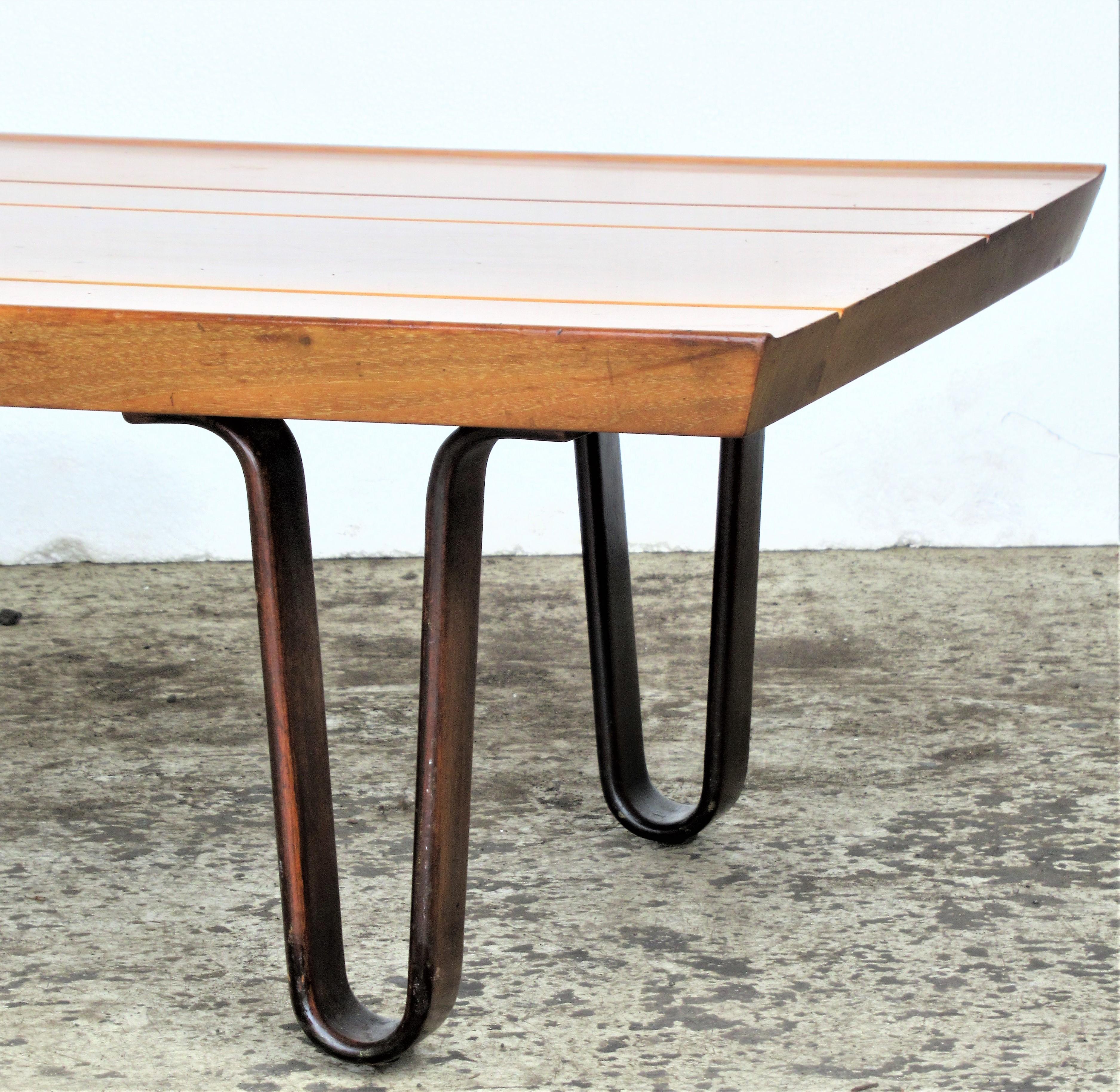 Long John one drawer coffee table / bench by Edward Wormley for Dunbar with beautifully contrasting glowing colors to grained natural walnut top and mahogany legs. Factory paper label on underside - Made by Dunbar Furn. Mfg. Co. - Berne, Indiana -