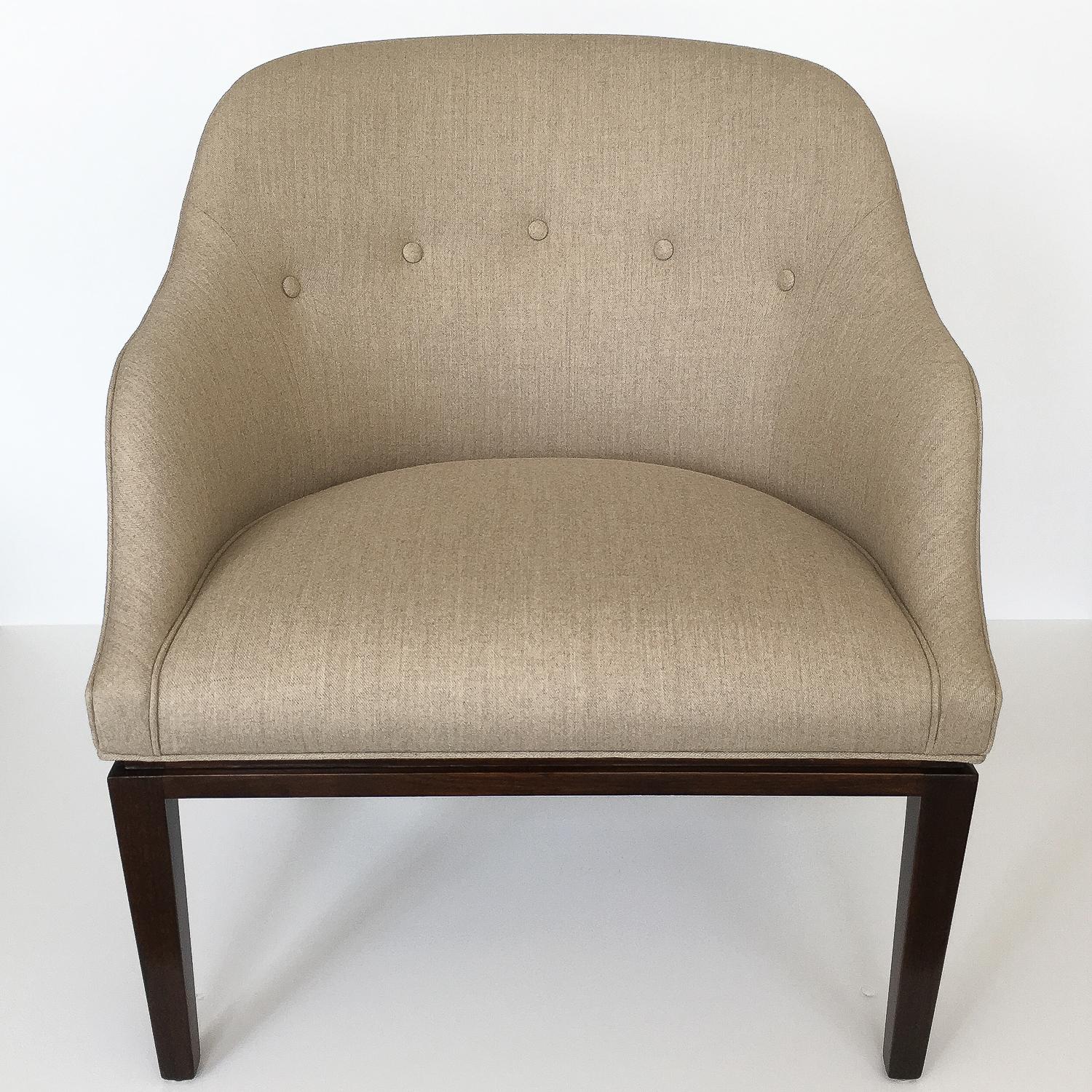 Sophisticated and tailored lounge chair by Edward Wormley for Dunbar, circa 1950s. Dark mahogany base with inset reveal just below the upholstery line. Curved back with splayed angled legs. Newly upholstered in a heathered natural oatmeal colored