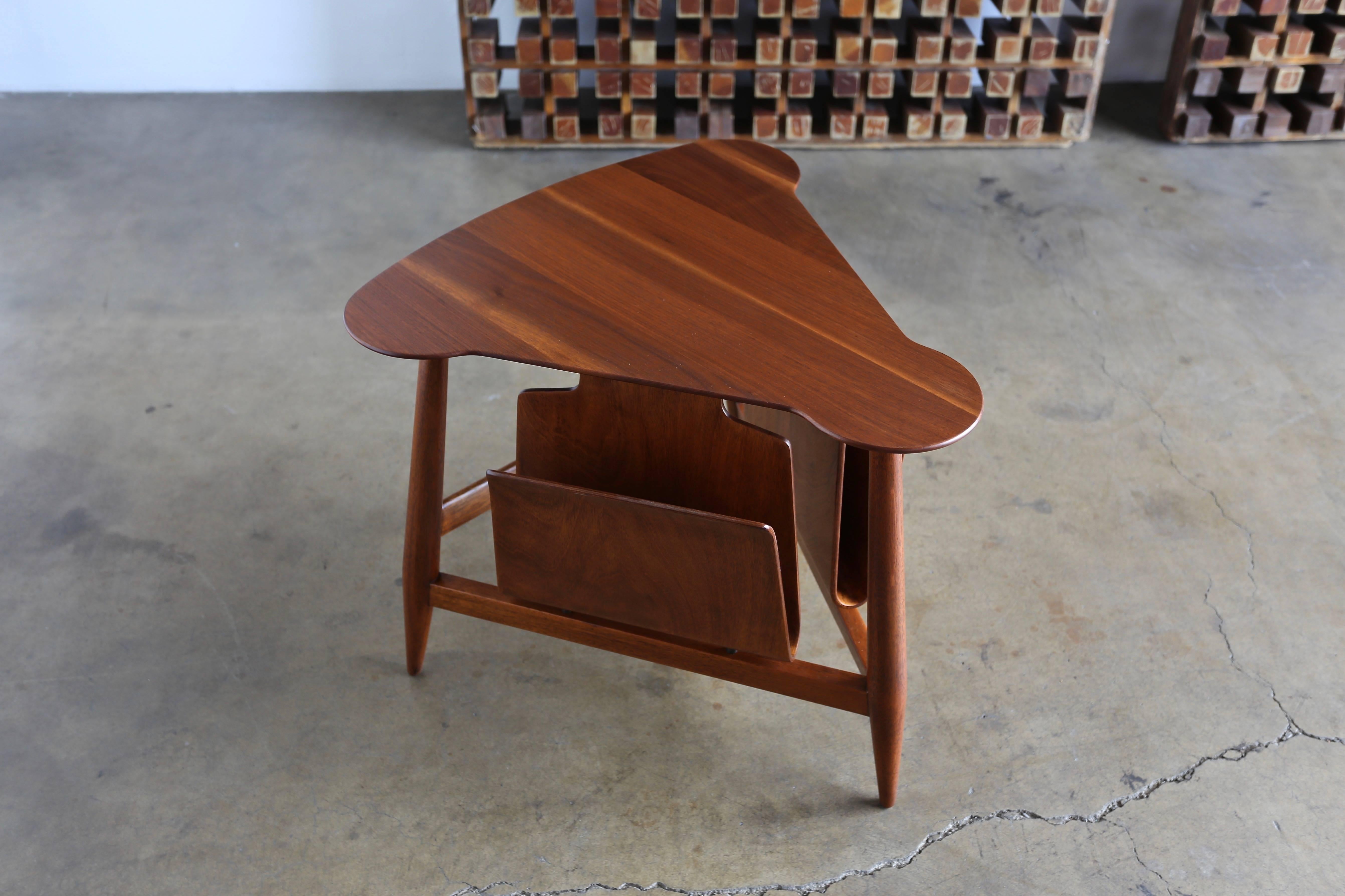 Edward Wormley magazine table model 5313. Manufactured by Dunbar, circa 1953. This table retains the original Dunbar tag to the bottom. This piece has been professionally restored.