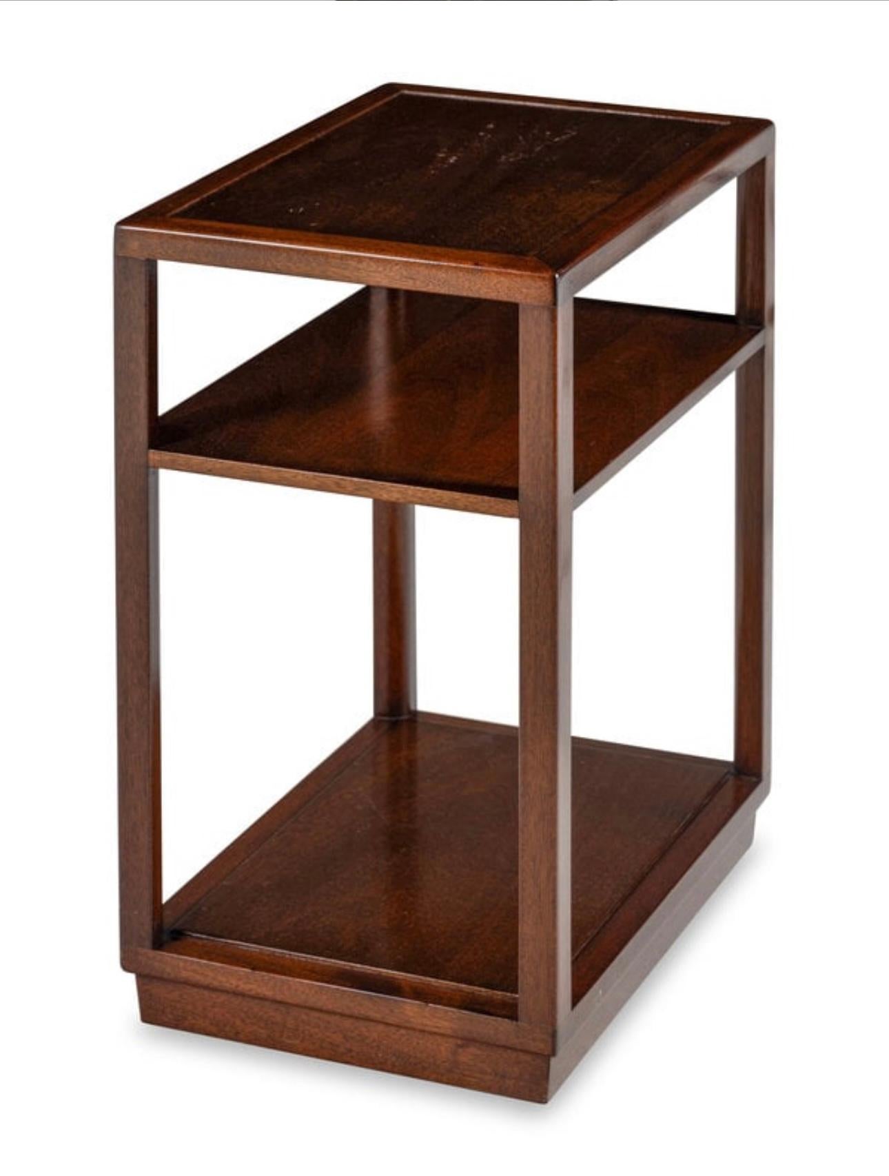 A single slim end table by Edward Wormley for Dunbar with rectangular top and a fixed shelf rising on plinth base.

Dark brown stained mahogany. 

USA, circa 1940-1950.

Signed with stamped burnished Dunbar name to underside.

Dimensions: 28 inches