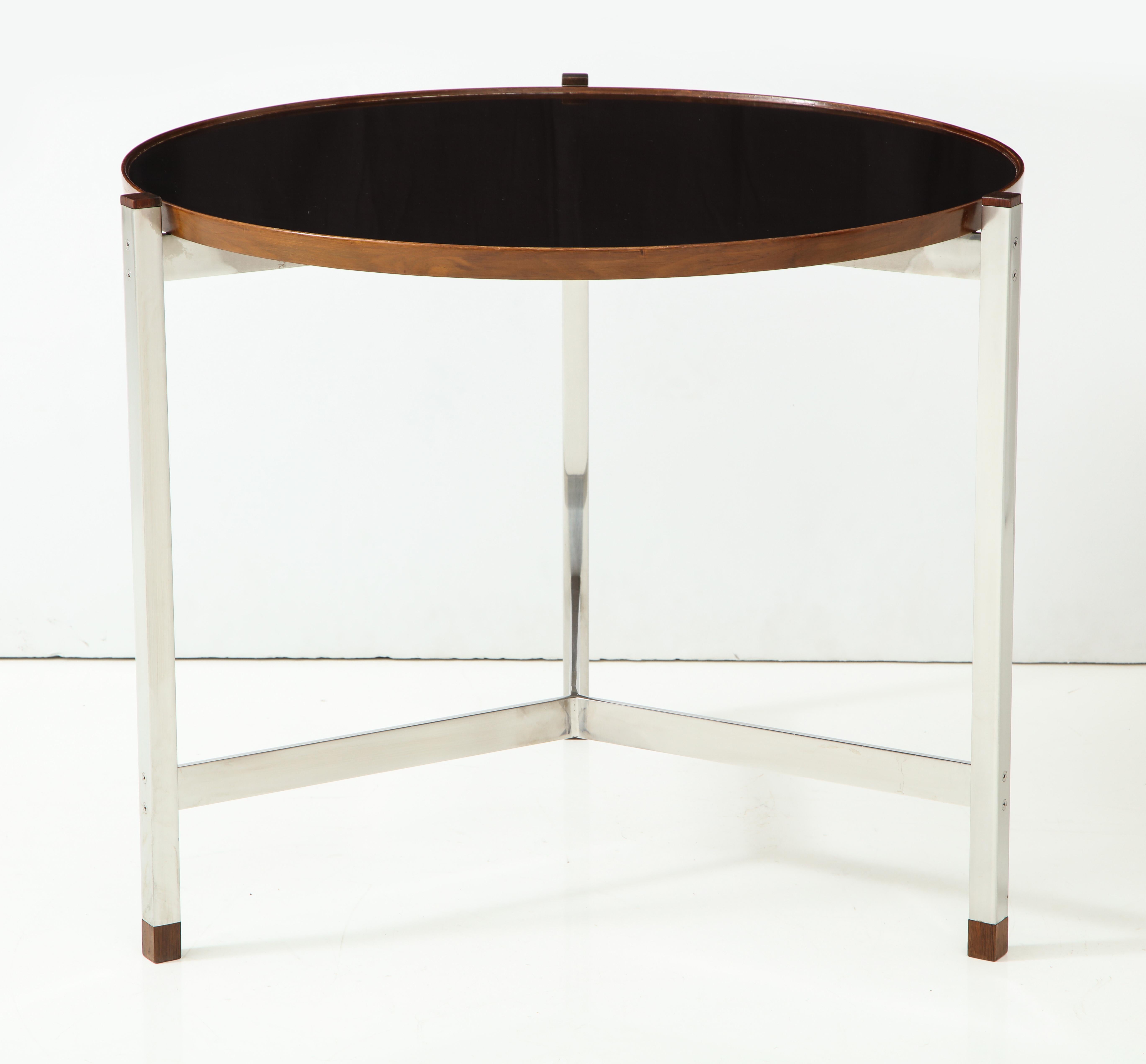 Round, rather large-scaled occasional table with a chromed steel three-leg base with flat cross stretchers and a top of black micarta with a walnut edge. Excellent proportions and details, including original set screws and Macassar ebony caps and