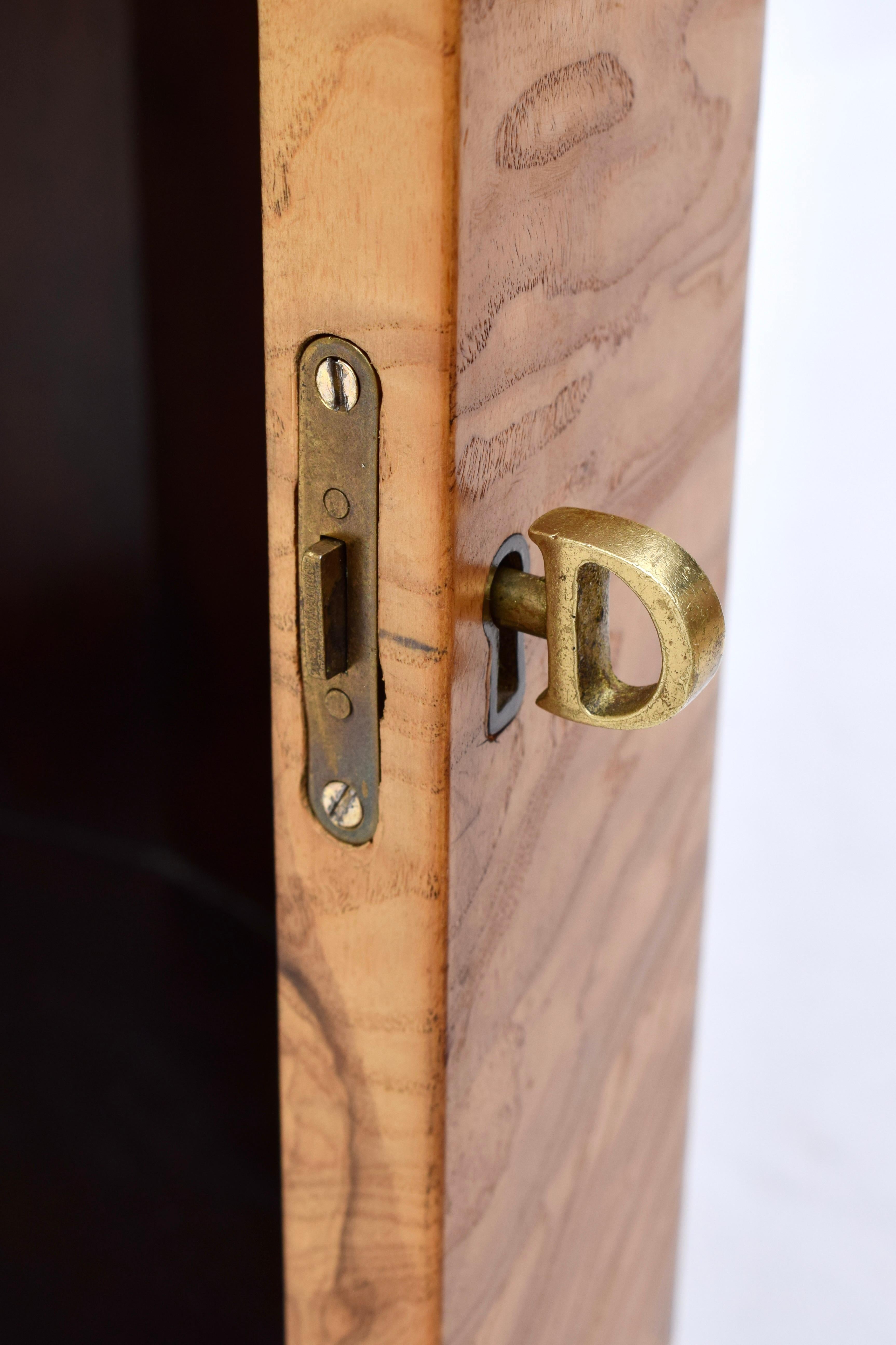 Faceted Pedestal Cabinet/ Dry Bar model 6302D by Edward Wormley for Dunbar, introduced in 1963, in natural olive burl with hinged door and dark mahogany interior cabinet.  Includes two brass Dunbar keys, original paper label on bottom and polished